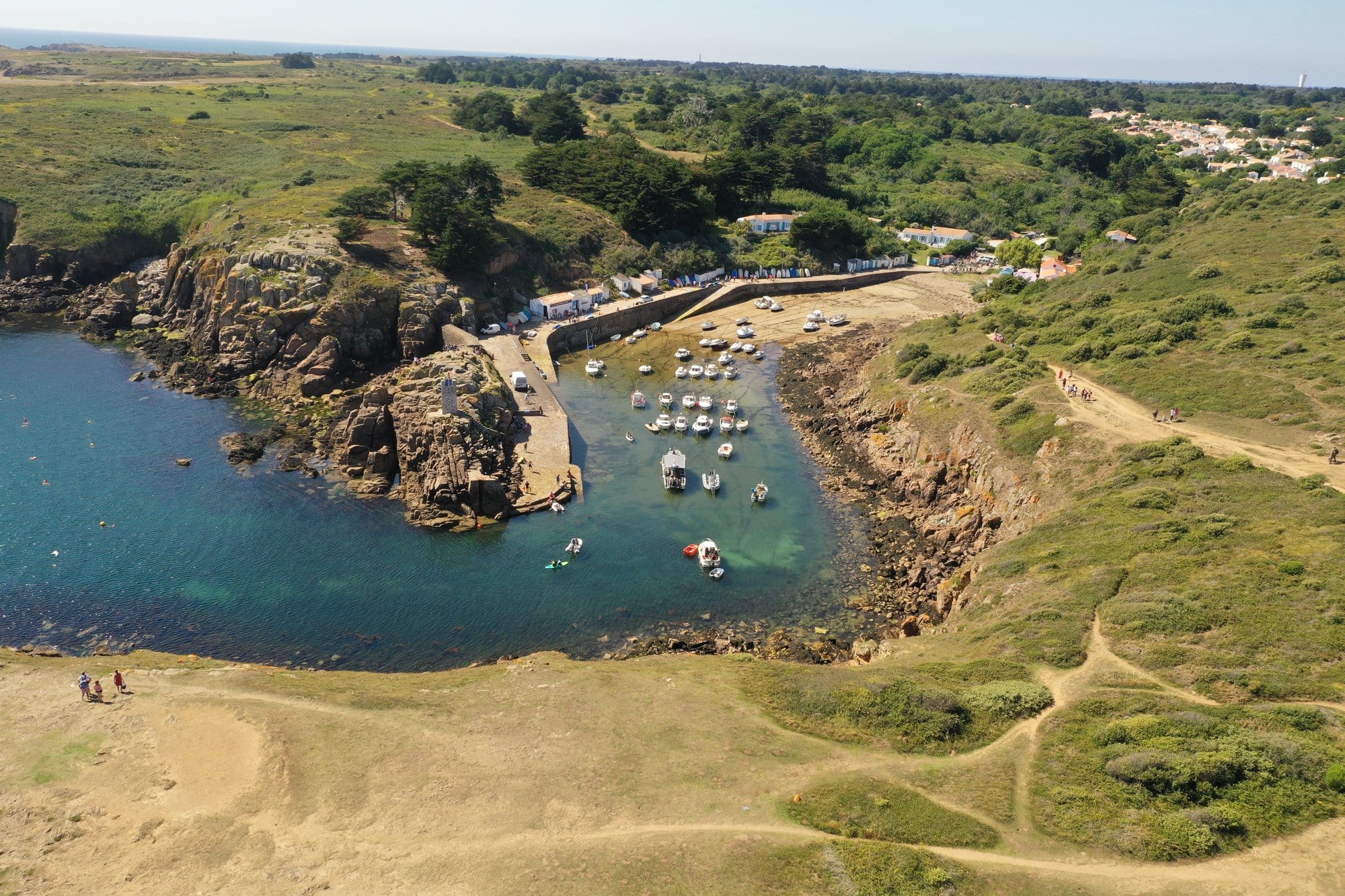 Aerial view of Port de la Meule's sheltered cove with moored boats and surrounding green landscape, captured with a DJI Mavic Pro 2 — Île d'Yeu, France