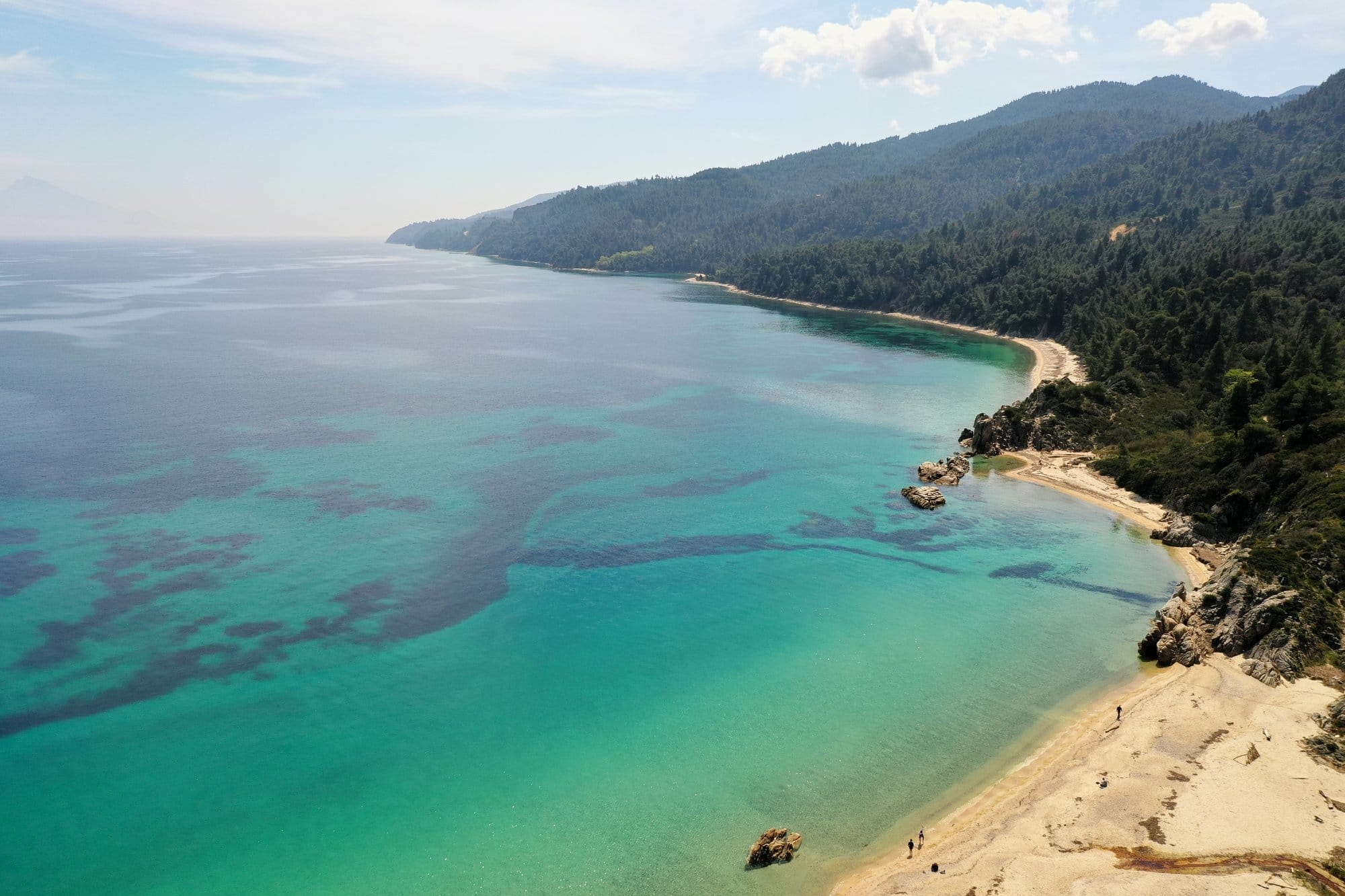 Large vue aérienne de la côte de Sithonia avec de l'eau turquoise et des collines couvertes de pins — Grèce