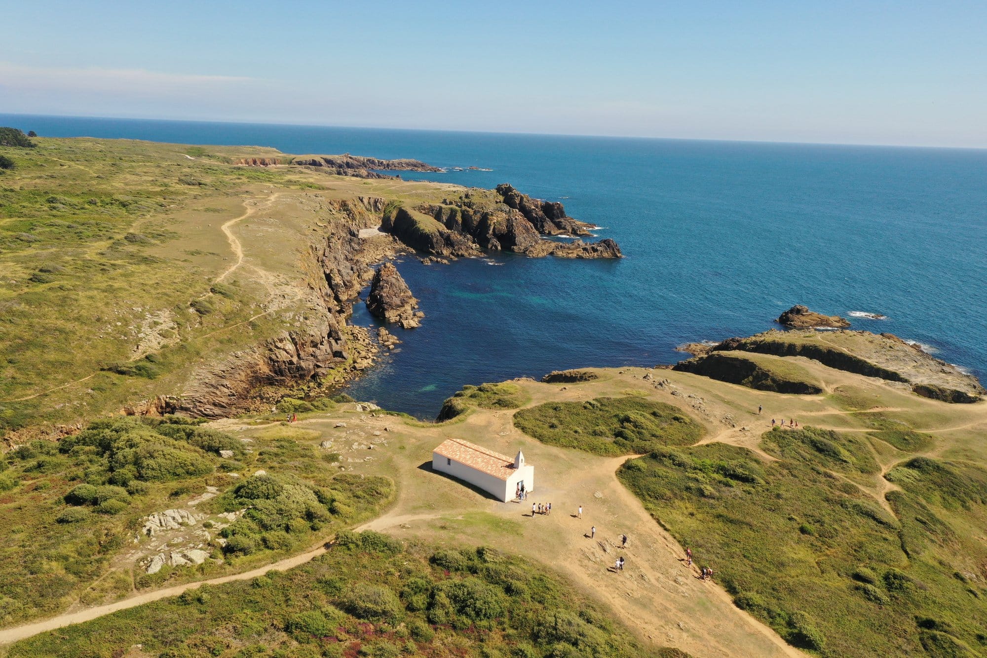 Aerial view of the Chapelle Notre-Dame-de-Bonne-Nouvelle, a small white chapel on a rocky headland overlooking the Atlantic, captured with a DJI Mavic Pro 2 — Île d'Yeu, France