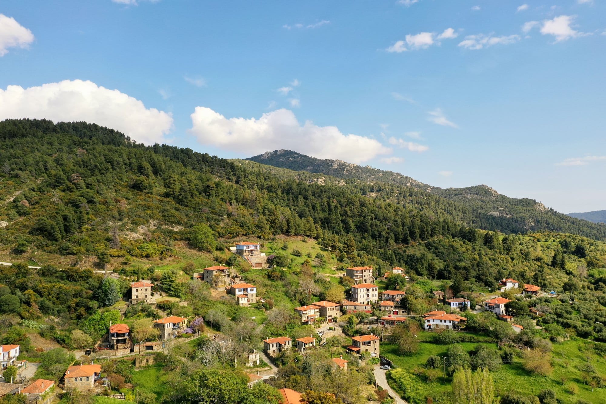 Vue aérienne du village en pierre de Parthenonas sur une colline boisée — Sithonia, Grèce
