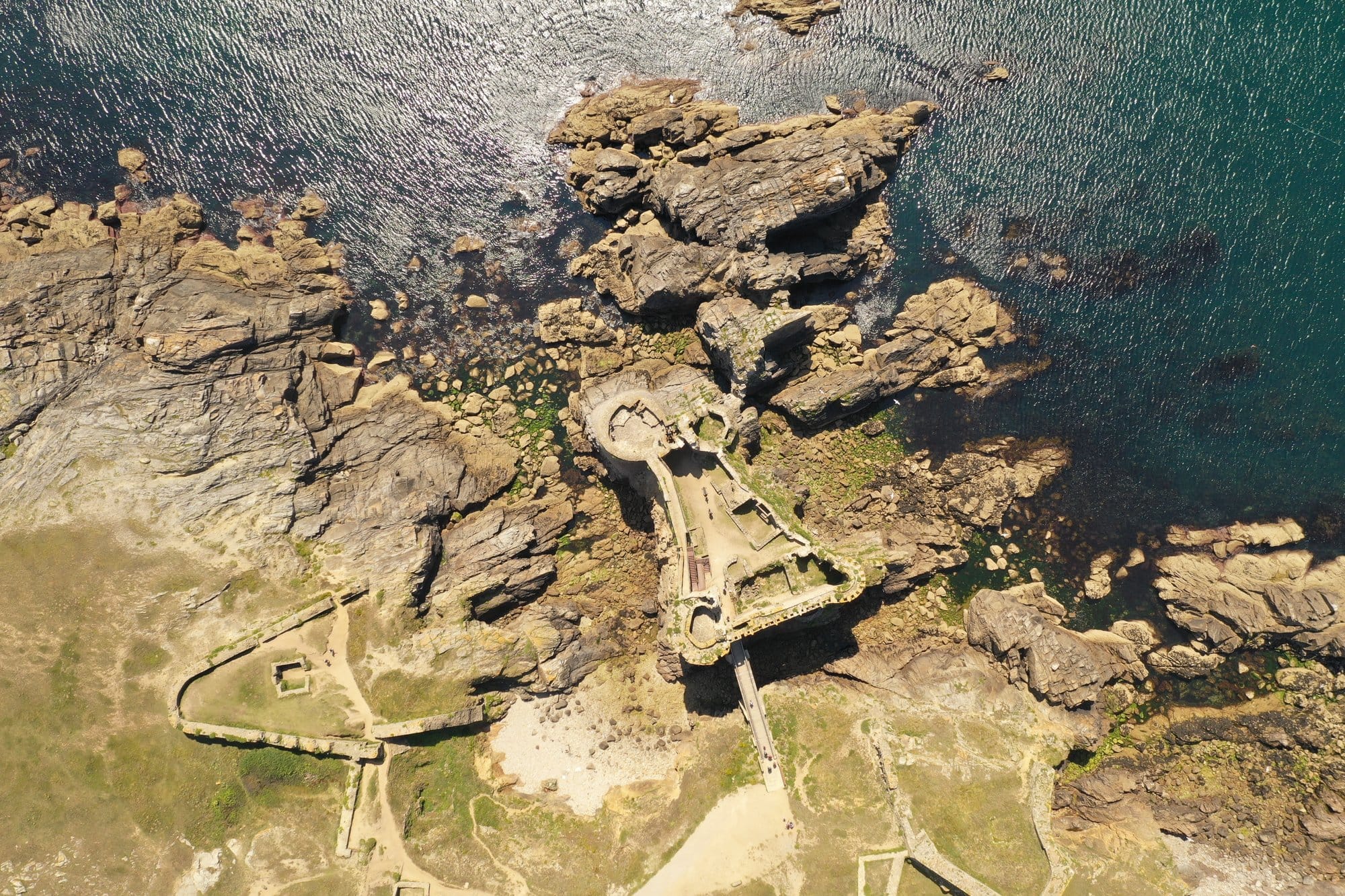 Top-down aerial view of the Vieux-Château ruins showing the medieval walls and ramparts built directly onto the rocky promontory, captured with a DJI Mavic Pro 2 — Île d'Yeu, France