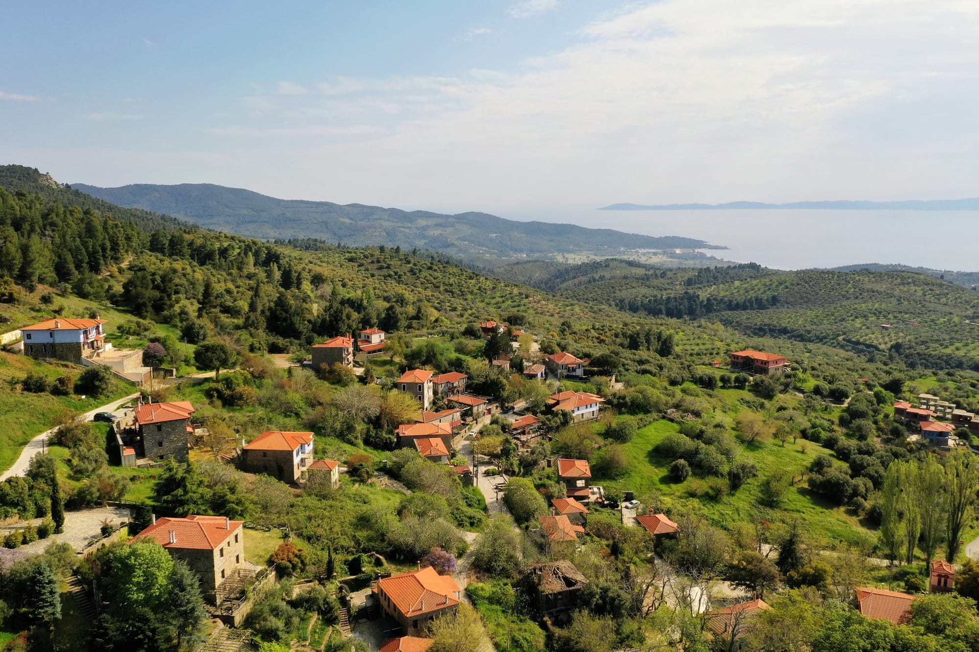 Parthenonas stone village nestled in forested hills with sea in the distance — Sithonia, Greece