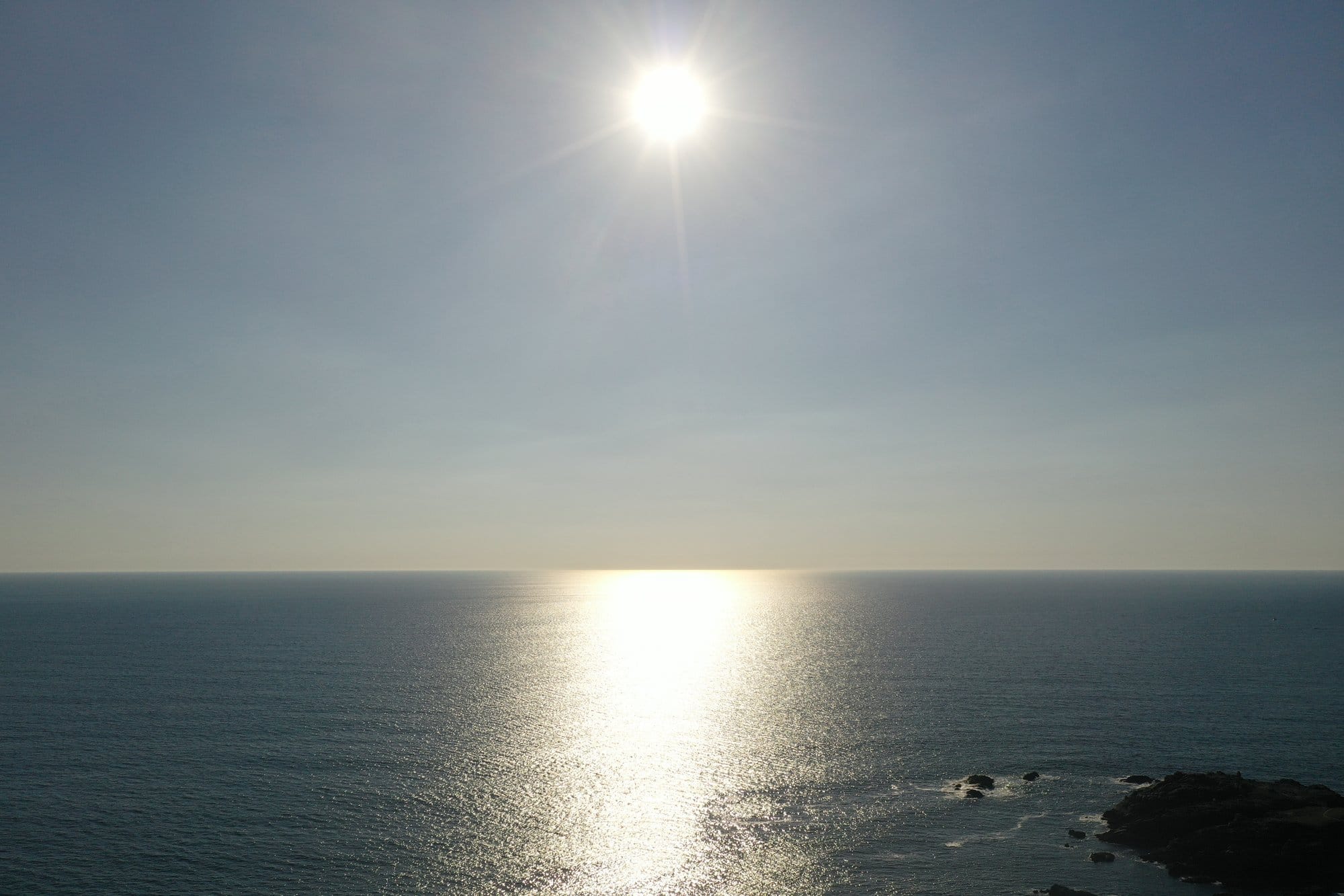 Sun setting over the open Atlantic seen from the western cliffs of Île d'Yeu, golden light reflected on the water surface, captured with a DJI Mavic Pro 2 — Île d'Yeu, France