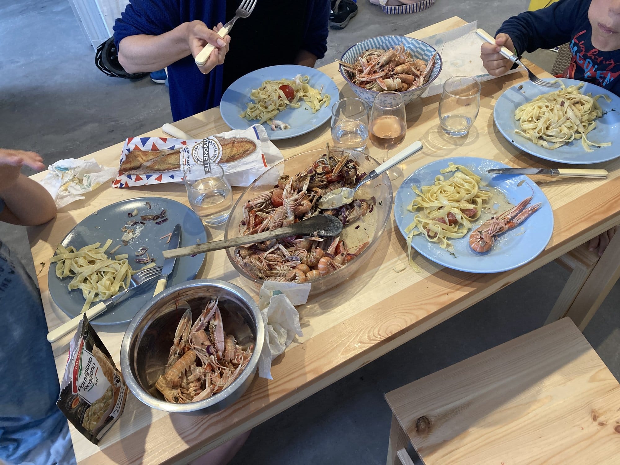 A generous spread of fresh langoustines, pasta with seafood, and glasses of rosé — a typical Île d'Yeu evening meal — Île d'Yeu, France