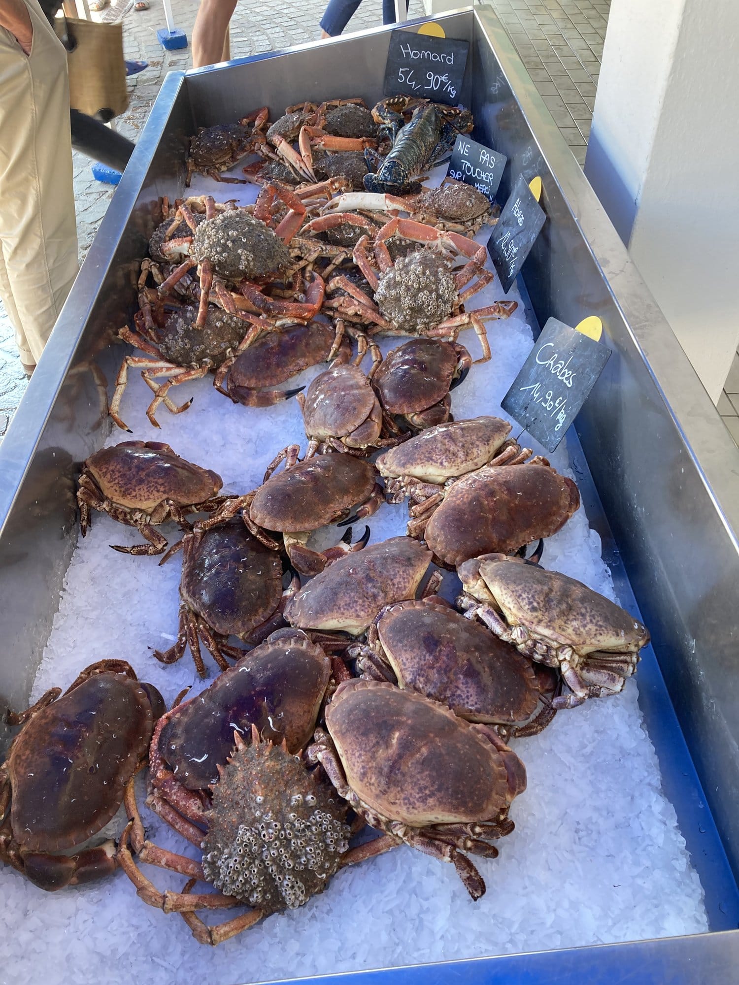 Fresh crabs, spider crabs and lobsters displayed on ice at the Port-Joinville fish market, handwritten price tags in chalk — Île d'Yeu, France