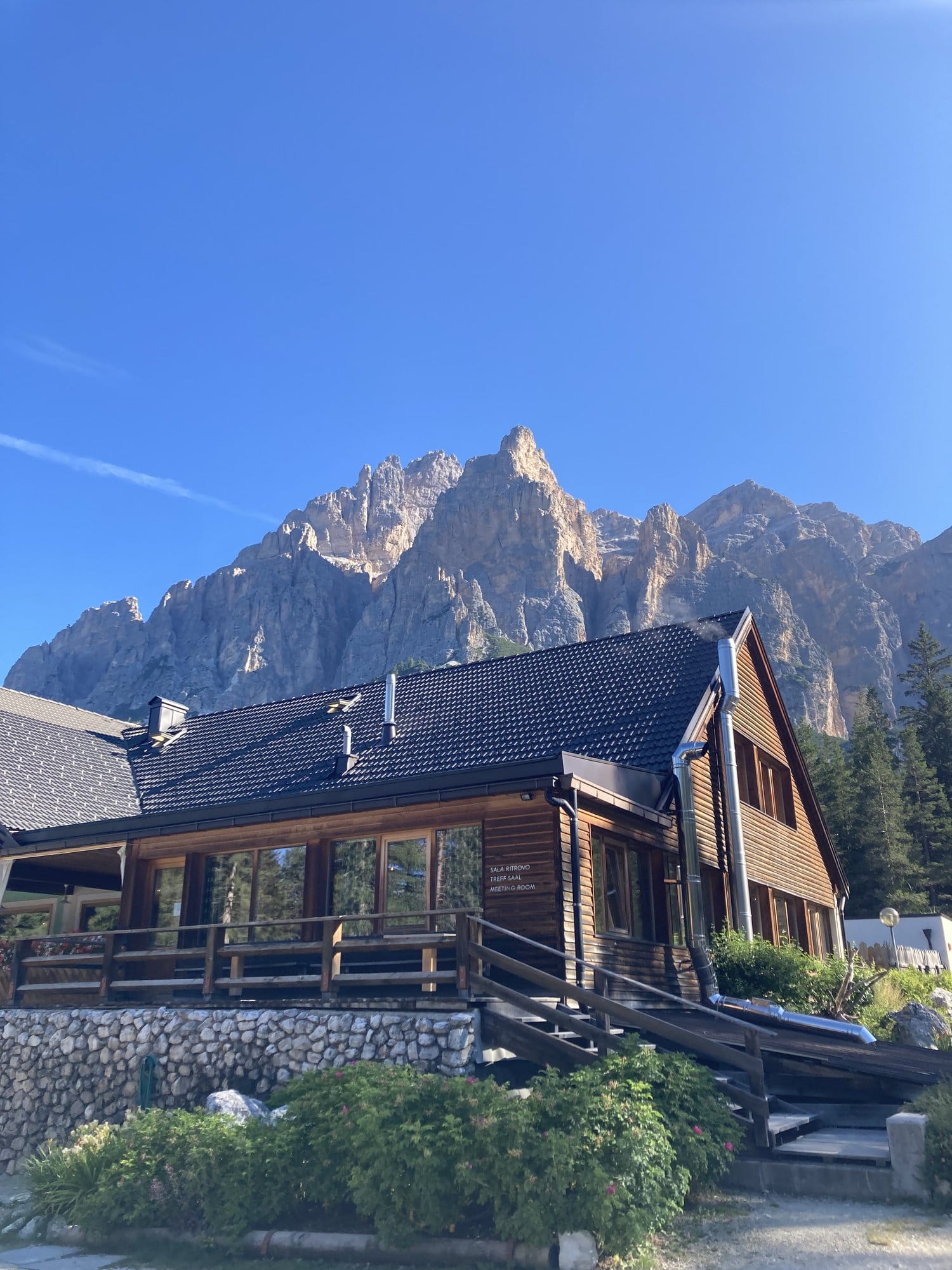 Mountain chalet with dramatic Dolomite walls in the background at Livinallongo โ Dolomites, Italy