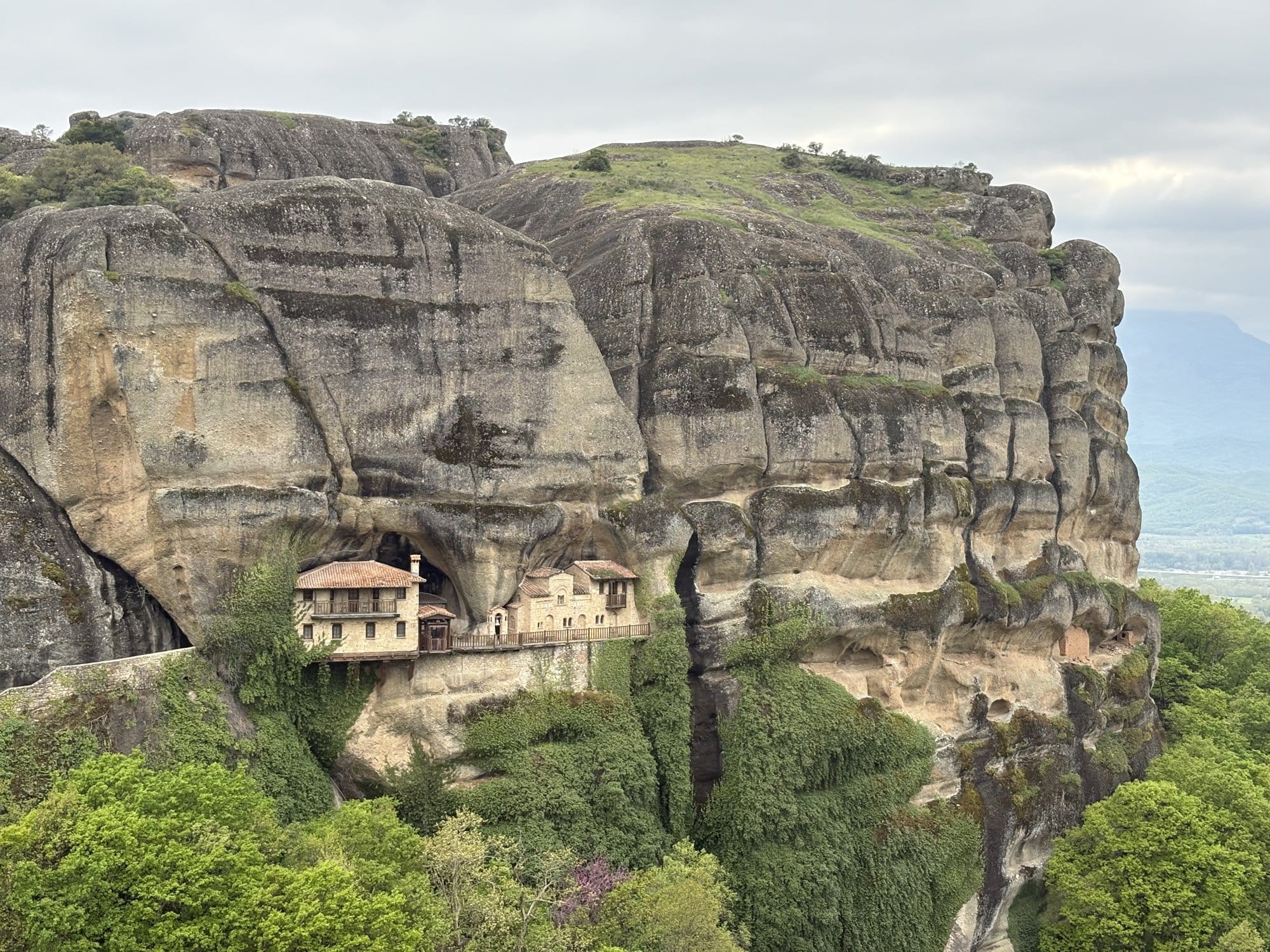 The tiny Ypapanti monastery tucked into a massive rock overhang — Meteora, Greece