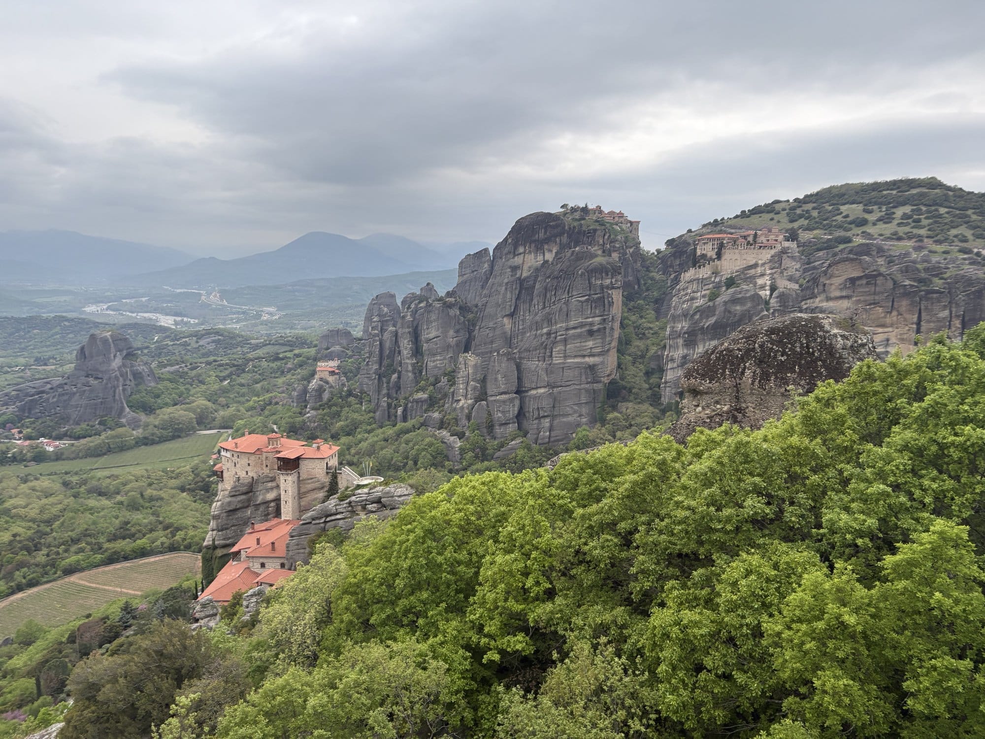 Two Meteora monasteries perched on their rock pillars seen from a viewpoint — Greece
