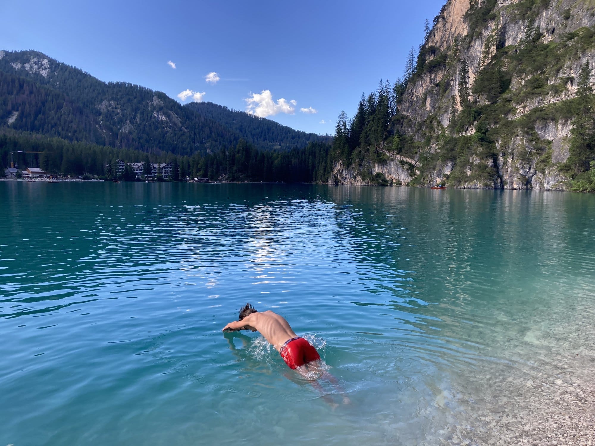 Swimming in the turquoise waters of Lago di Braies on a summer afternoon โ Dolomites, Italy