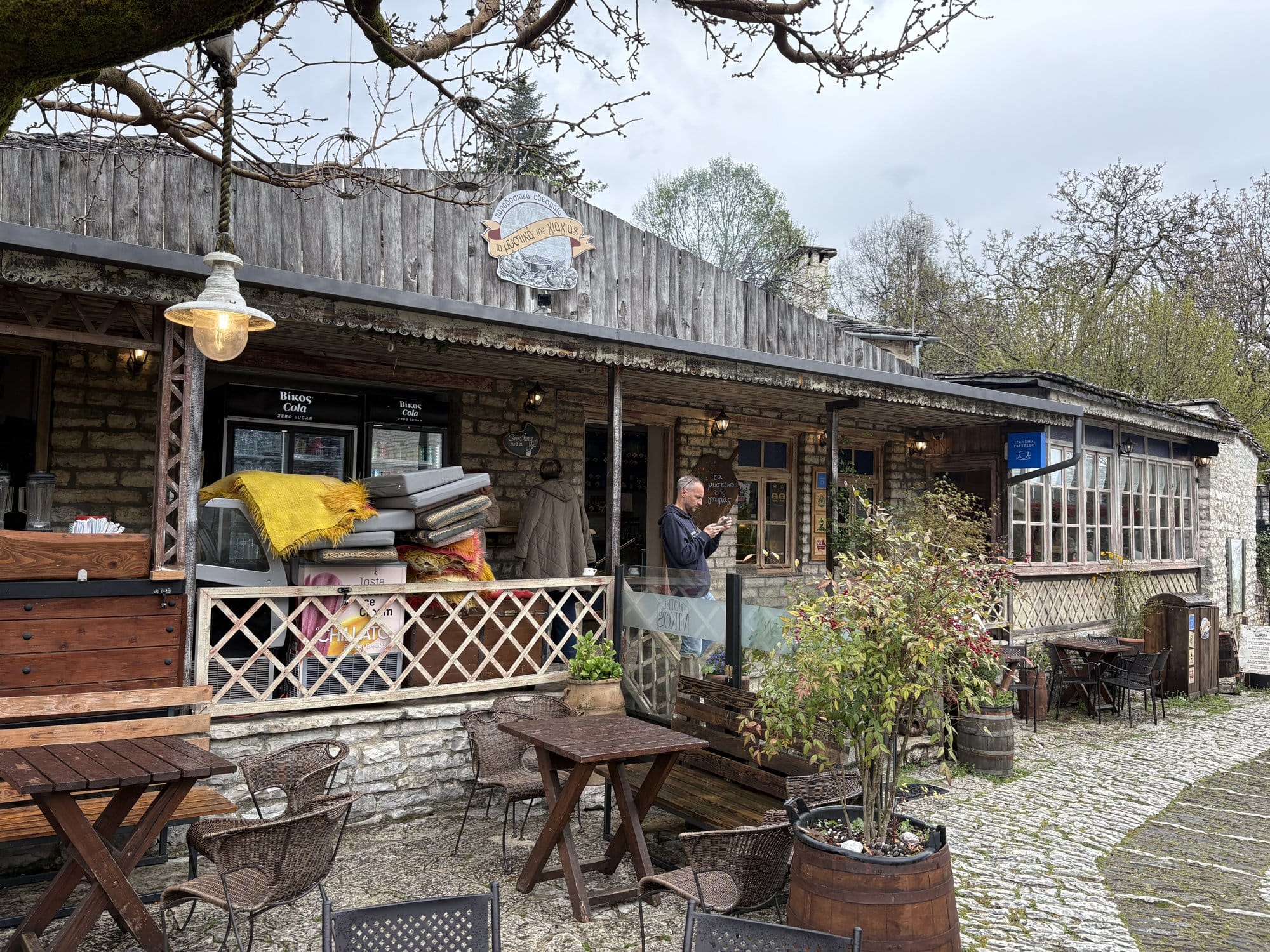 Taverne rustique en bois avec terrasse et tables de café dans un village du Zagori — Grèce