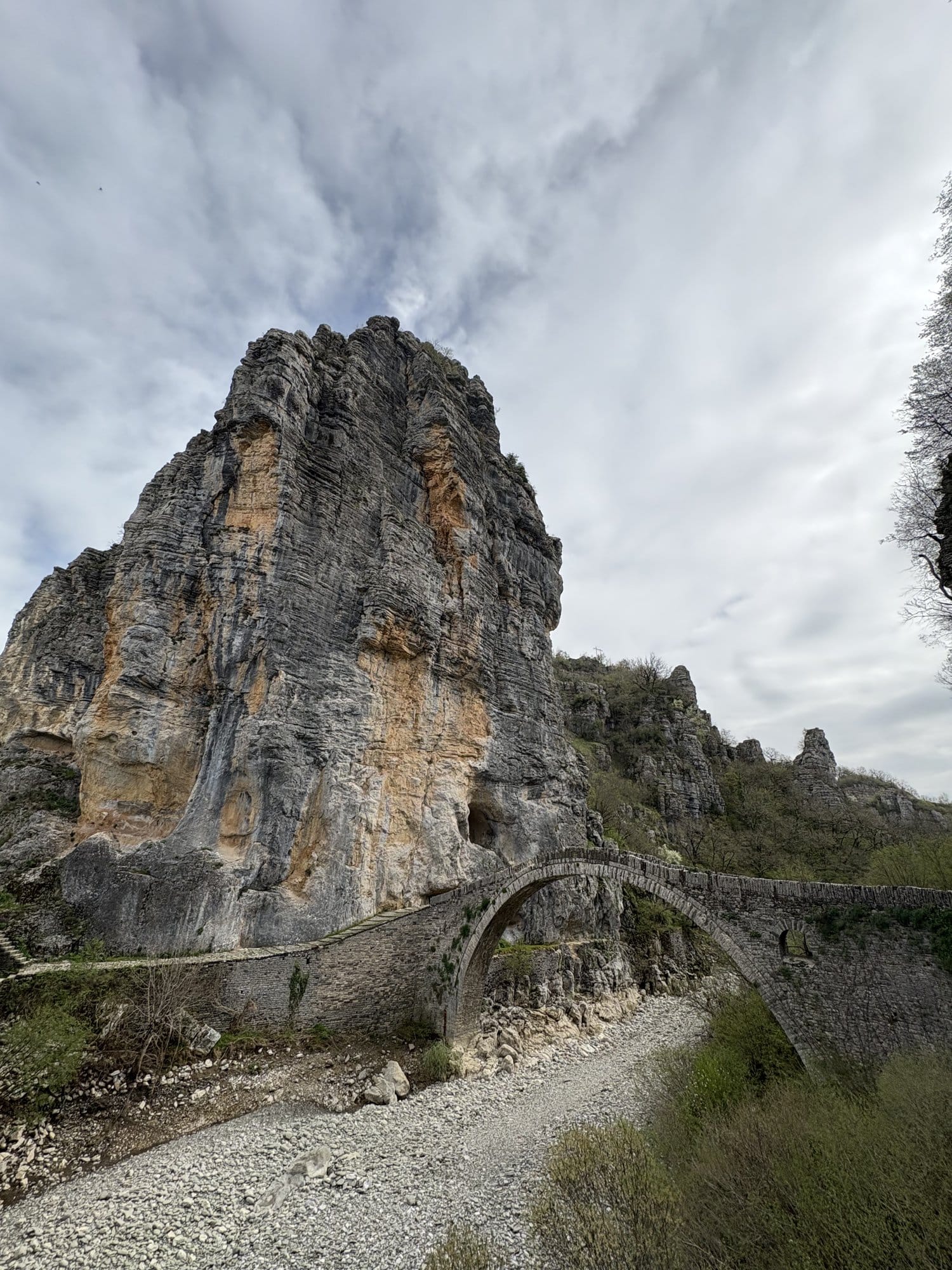 Stone arched bridge at the foot of a big limestone rock — Zagori, Greece