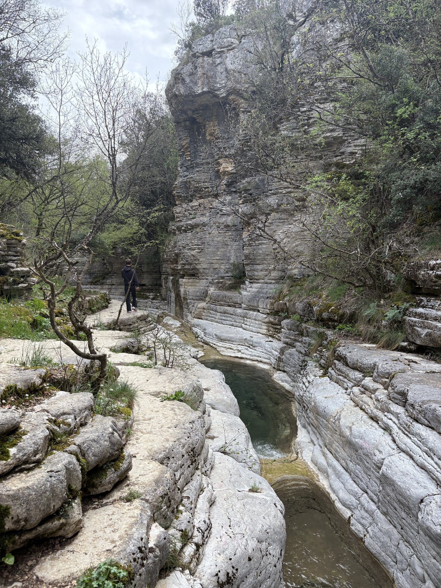 Randonneur marchant le long des vasques calcaires (Kolymbithres) au-dessus de Papingo — Zagori, Grèce