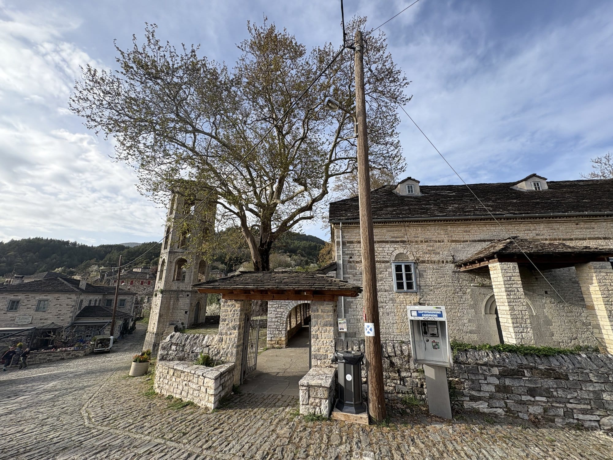 Central square of Papingo village with a plane tree and the stone church — Zagori, Greece