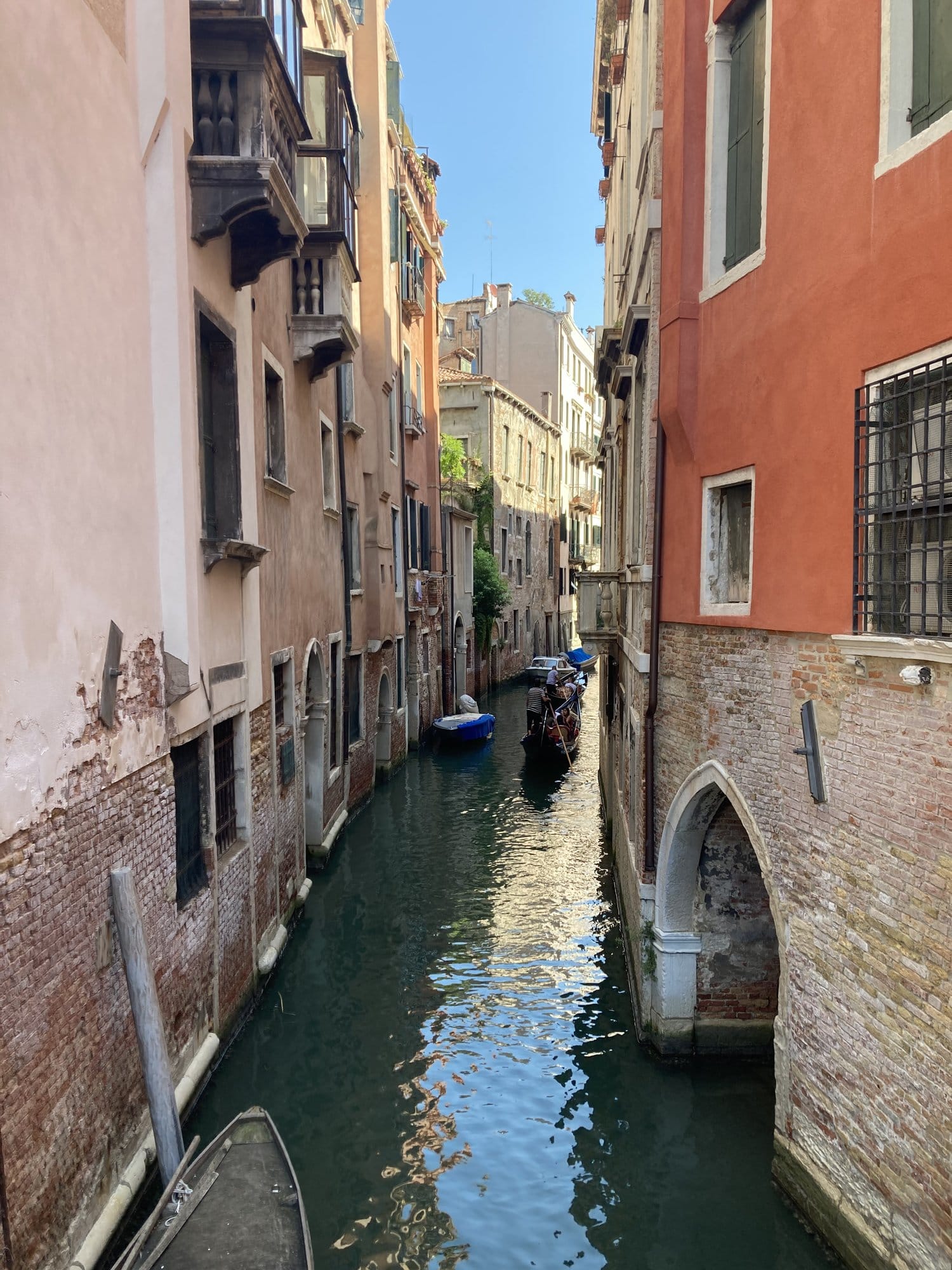 Narrow canal with gondola and colorful facades in Castello — Venice, Italy