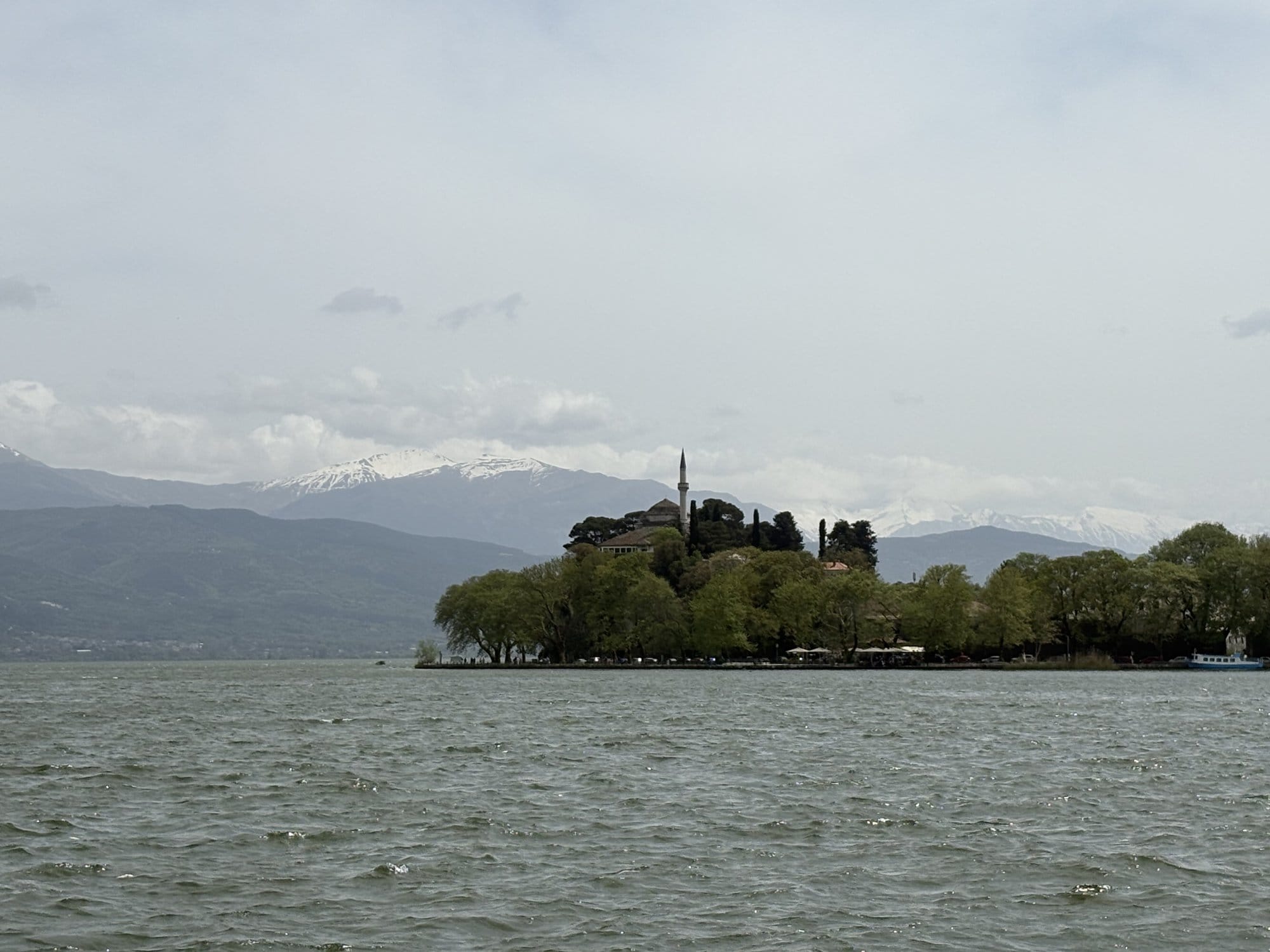 Nisaki island on Lake Pamvotida with a minaret and snow-capped Pindus mountains behind — Ioannina