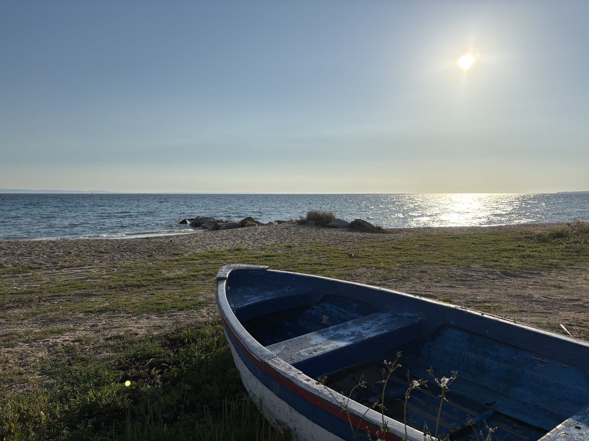 Bateau de pêche bleu sur une plage de sable à Nikiti au coucher du soleil — Halkidiki, Grèce