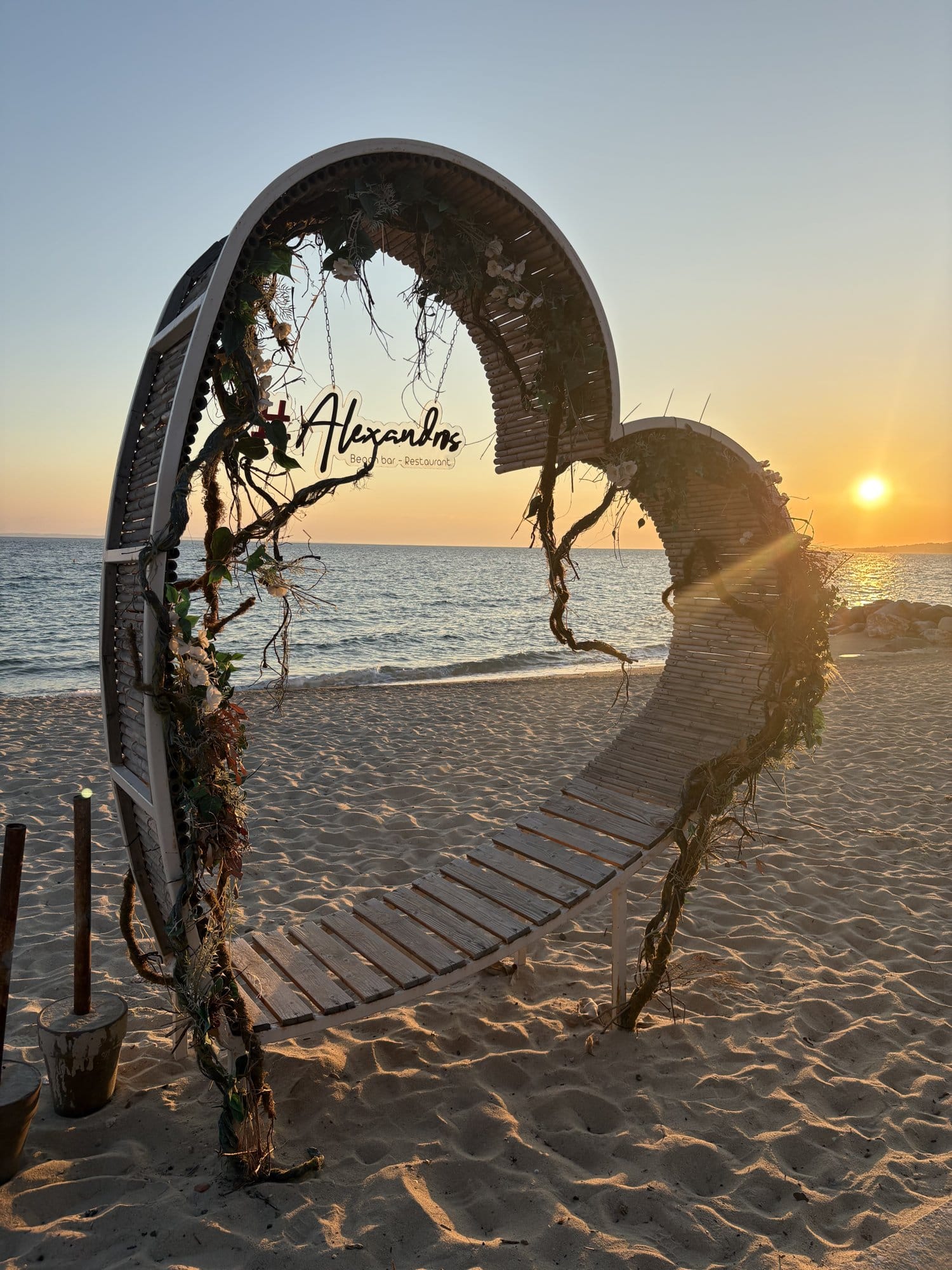 Banc décoratif en bois en forme de lune sur une plage de Nikiti au coucher du soleil — Halkidiki, Grèce