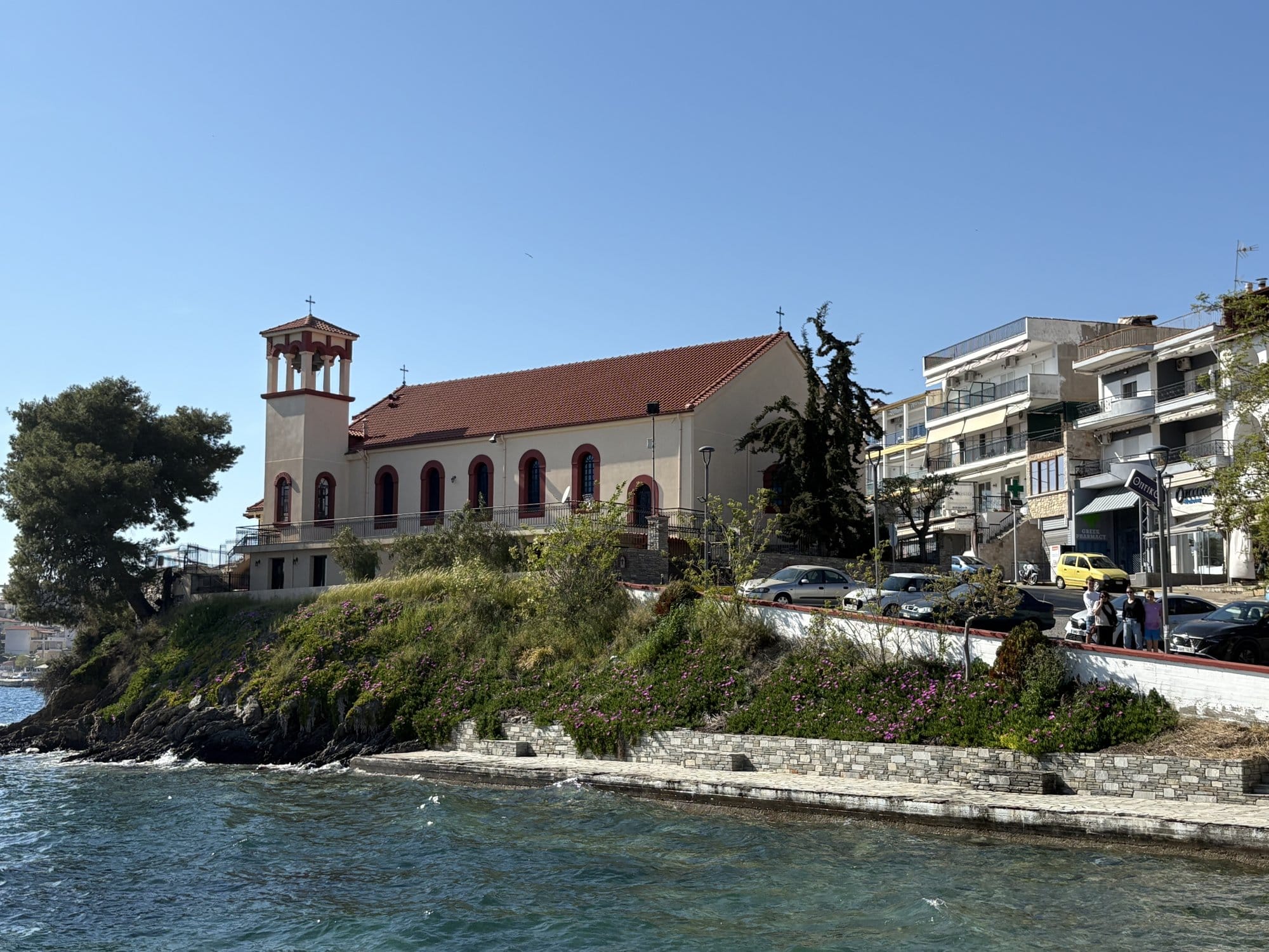 Église blanche au bord de la mer avec clocher à tuiles rouges à Neos Marmaras — Halkidiki, Grèce