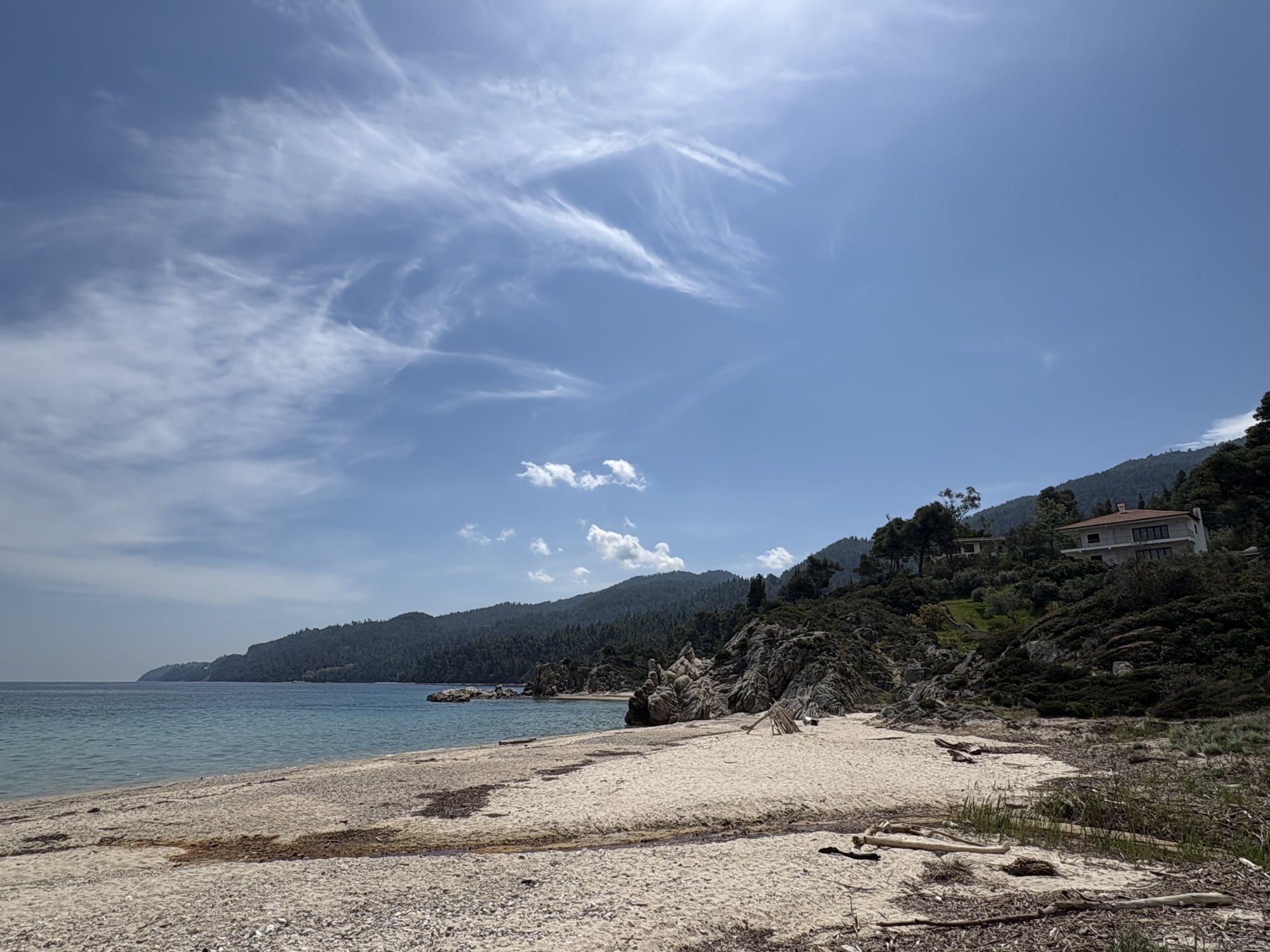 Plage de sable de Sithonia avec rochers, pins et une villa sur la colline — Grèce