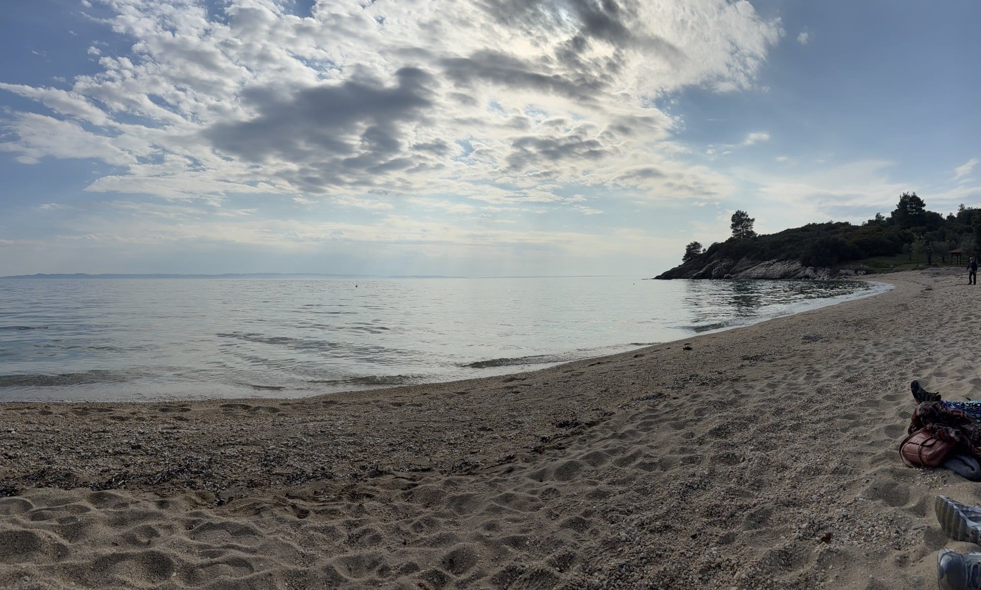 Grande plage sableuse à Sithonia avec nuages et péninsule boisée de pins — Grèce