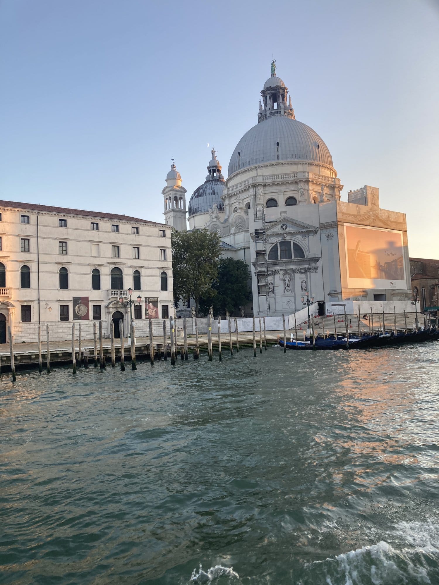 Basilica della Salute seen from the water at sunset with mooring poles — Venice, Italy