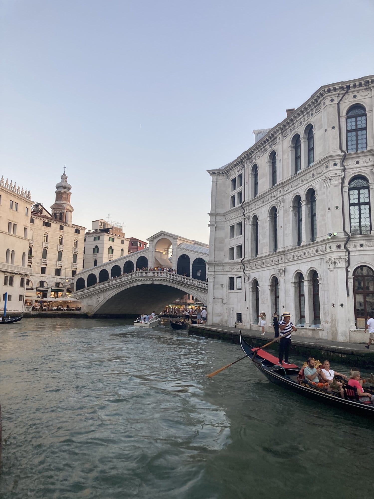 Ponte di Rialto with gondola and vaporetto at dusk — Venice, Italy