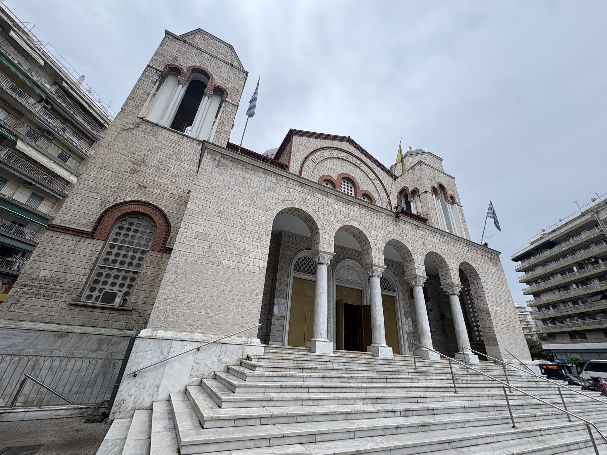Façade en pierre blanche d'une église orthodoxe avec escalier en marbre et portique à colonnes — Thessalonique, Grèce