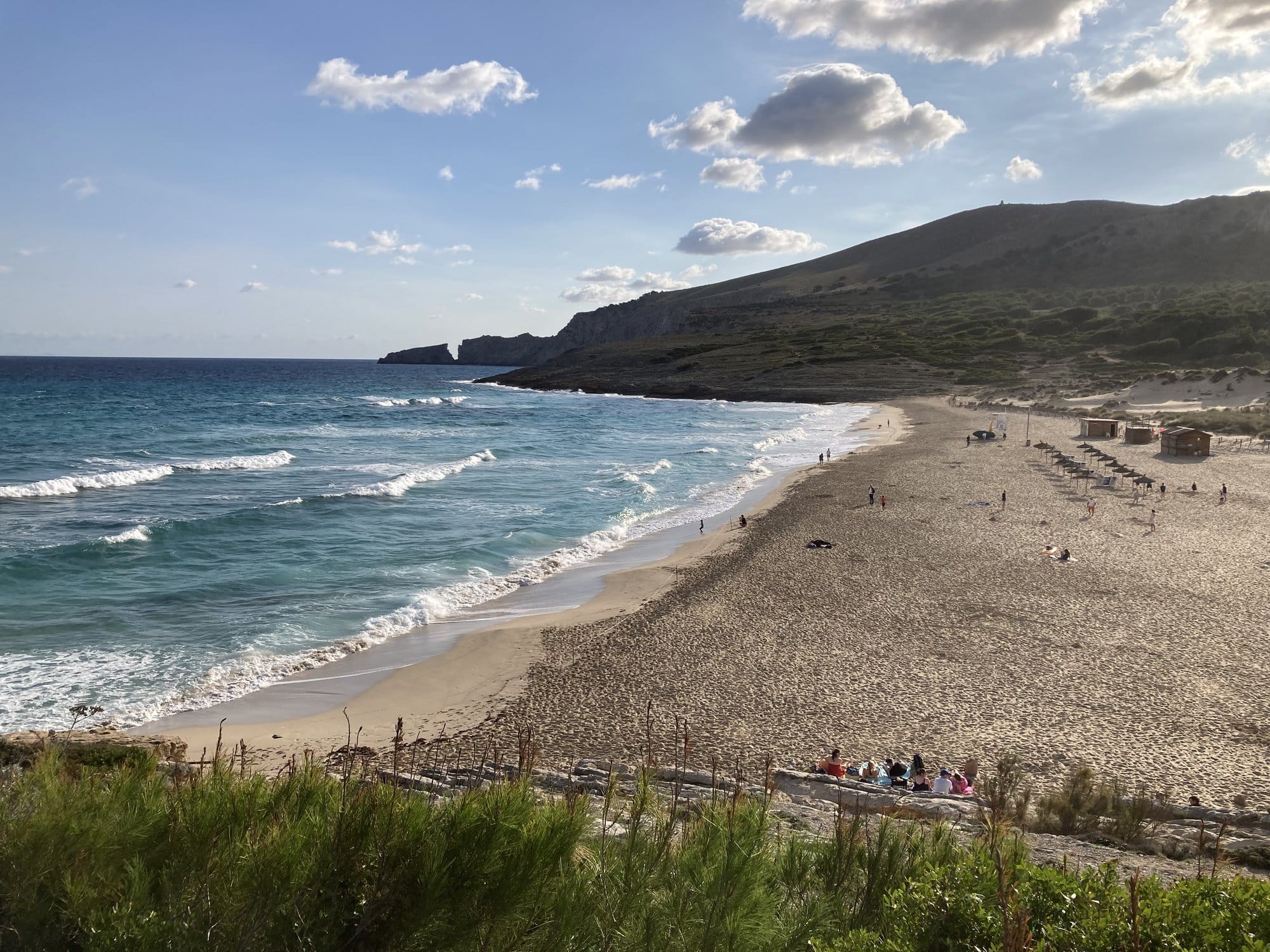 Rocky beach with swimmers and families enjoying the water — Capdepera, Spain