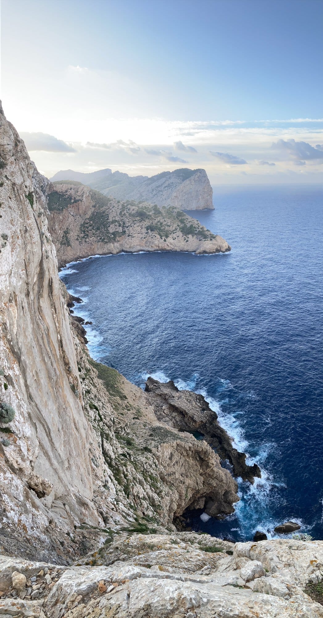 Towering pale limestone cliffs crowned with sparse vegetation — Cap de Formentor, Spain