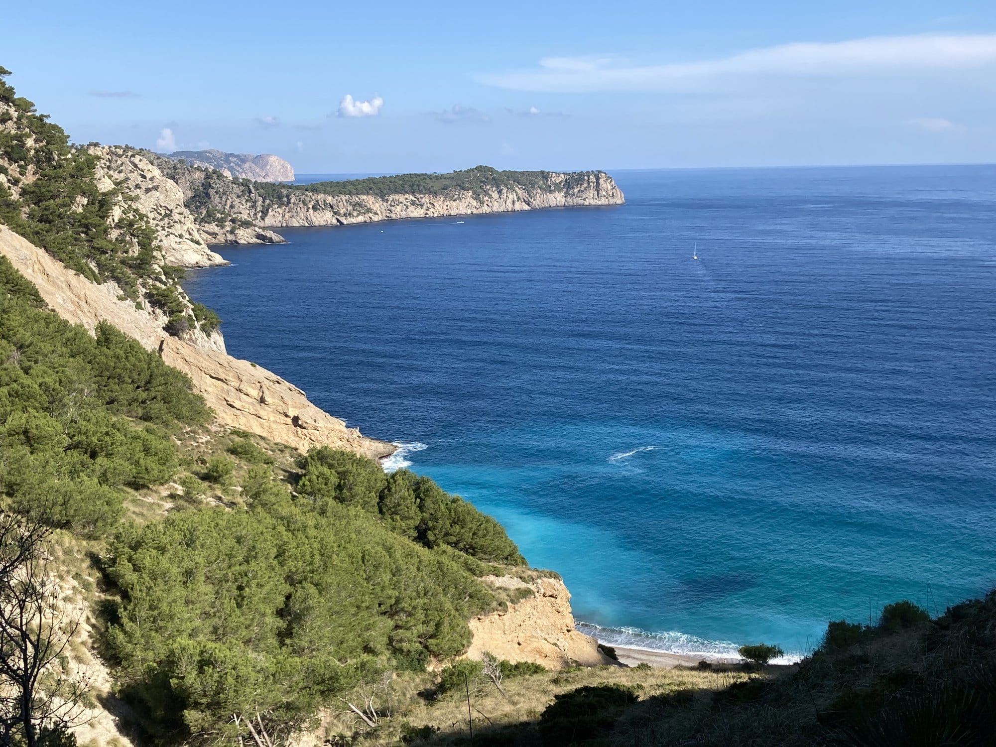 White and cream-colored limestone cliffs framing a sheltered beach — Alcanada, Spain