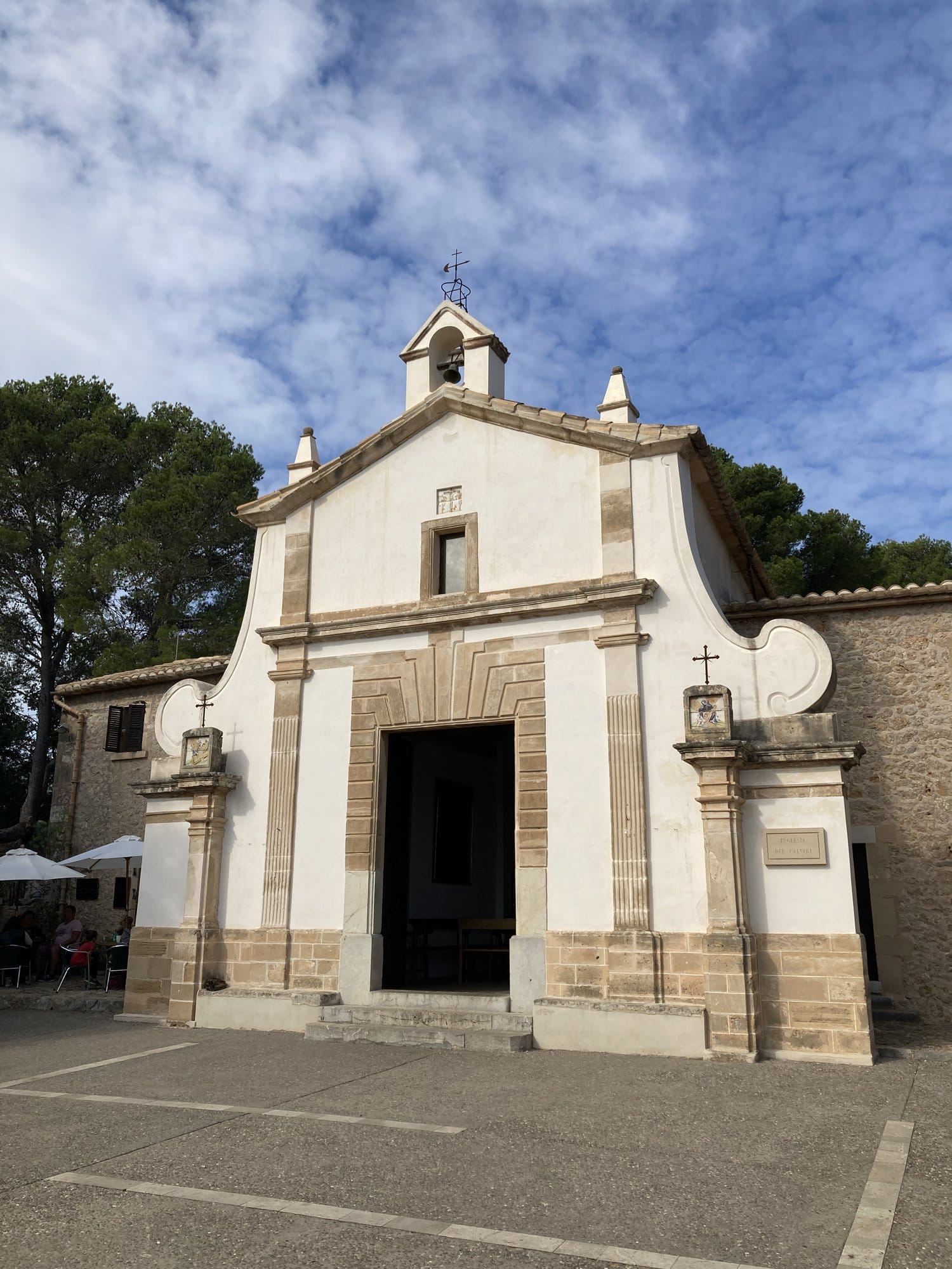 A whitewashed chapel among olive trees — Pollença, Spain