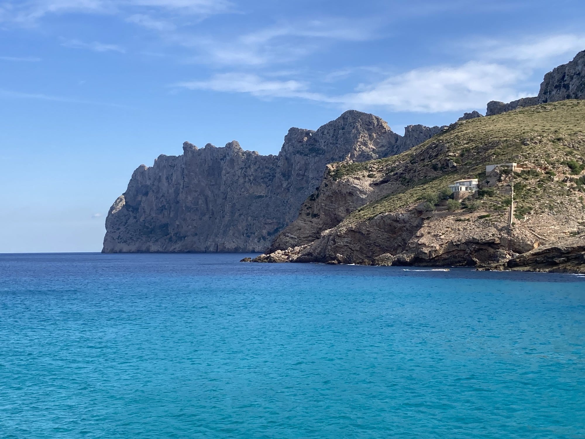 Clear cove water framed by limestone cliffs — Cala Sant Vicenç, Spain