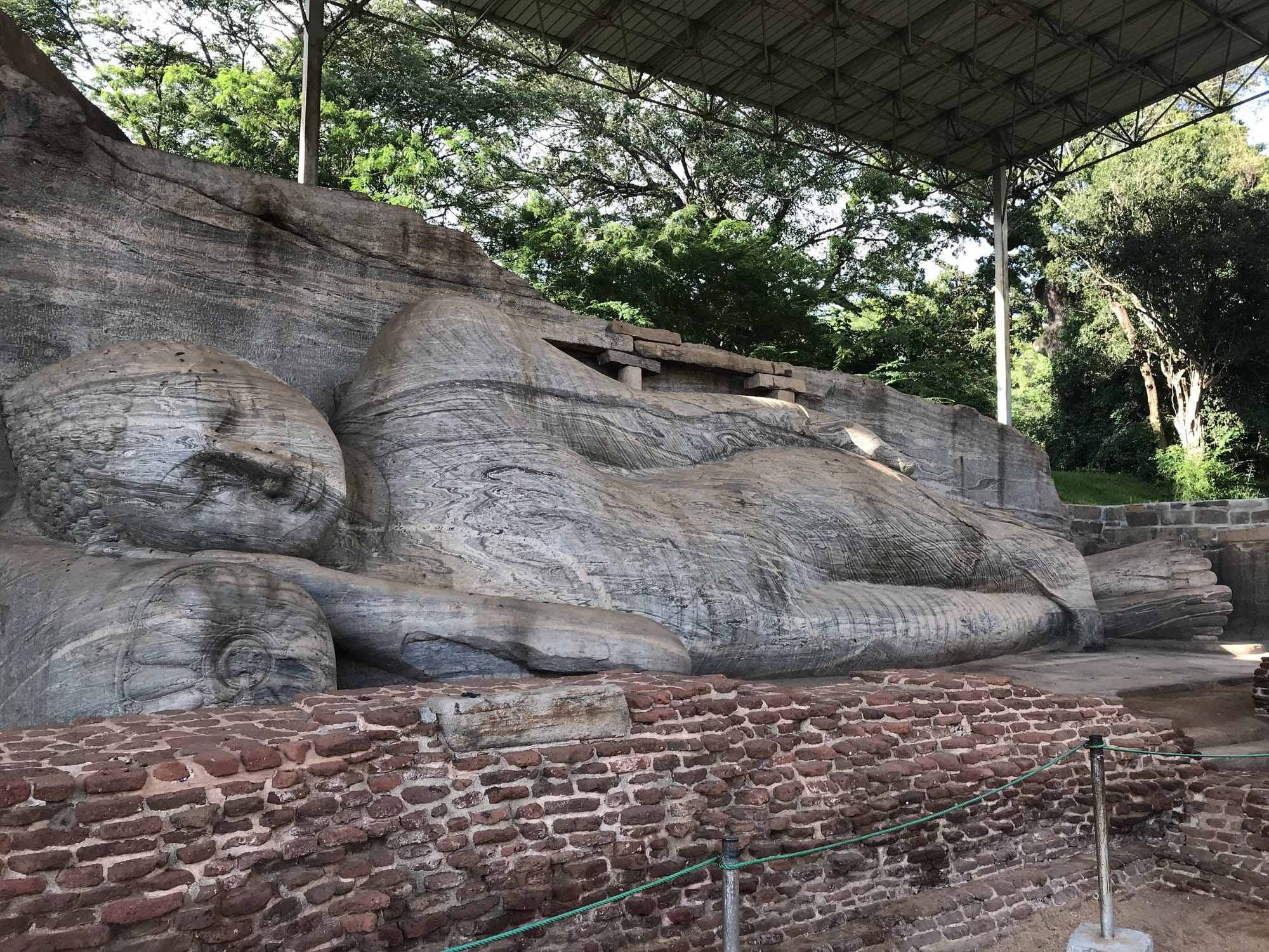 The magnificent reclining Buddha statue at Gal Vihara, carved into living rock with serene expression and intricately detailed robes — Polonnaruwa, Sri Lanka