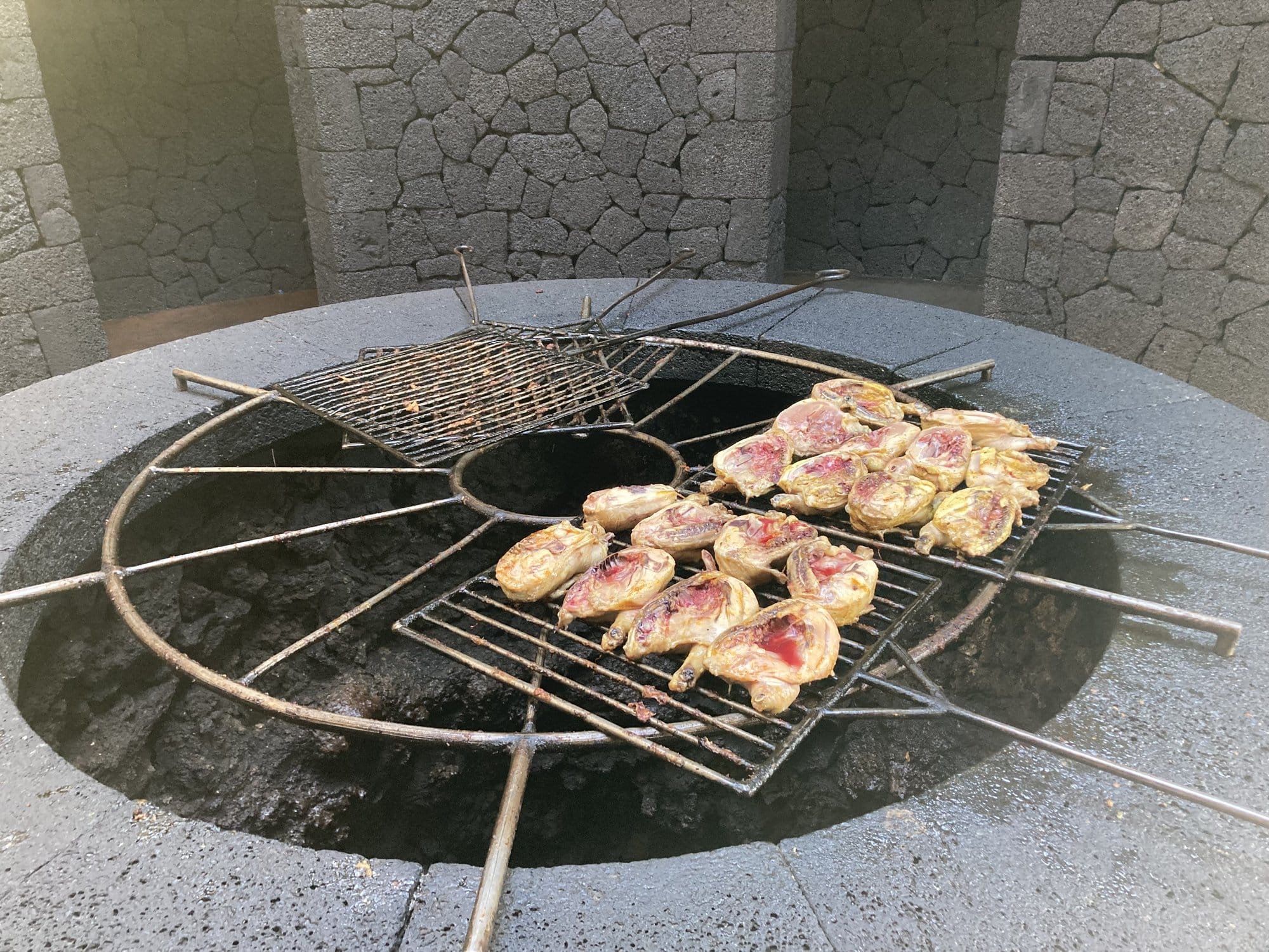 Meat grilling over a volcanic vent at El Diablo restaurant in Timanfaya — the heat comes directly from the magma beneath the surface — Lanzarote