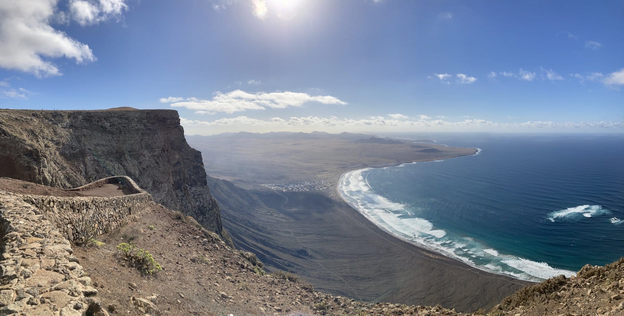 Panoramic view of Lanzarote's northern coastline from Teguise area showing volcanic mountains, golden cliffs and dramatic landscape under blue sky — Lanzarote