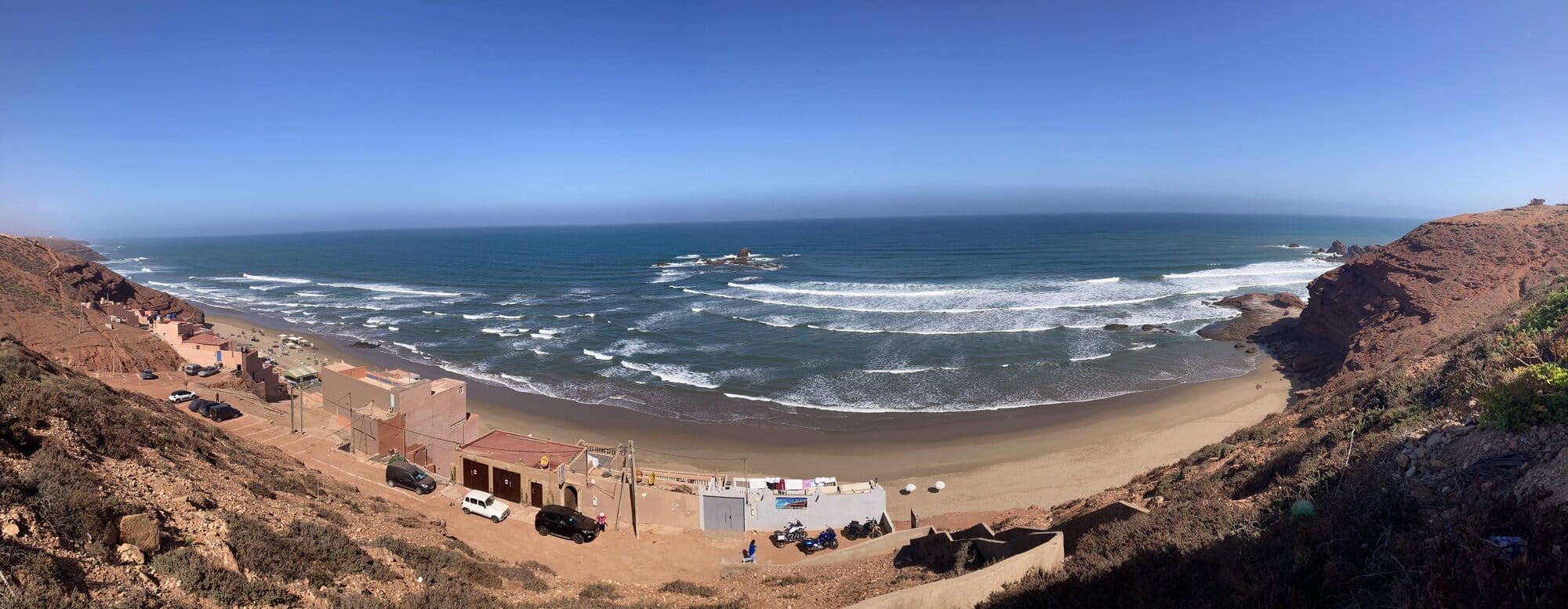 A wide rocky bay near Legzira — crescent beach with a small offshore rock — Mirleft area, Morocco
