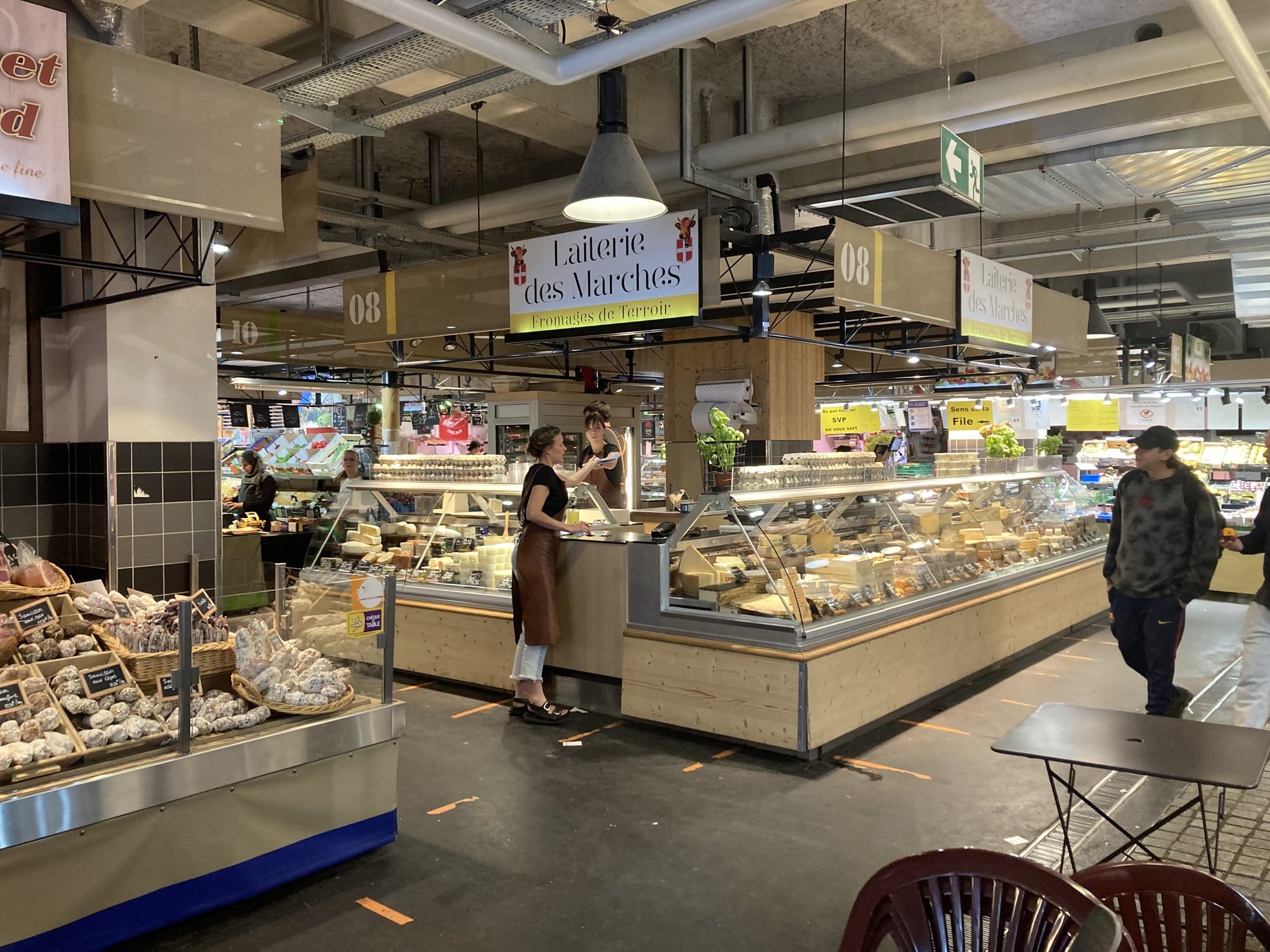 The Laiterie des Marches cheese counter at Les Halles market in Chambéry, displaying an impressive range of Savoyard cheeses — Chambéry, France
