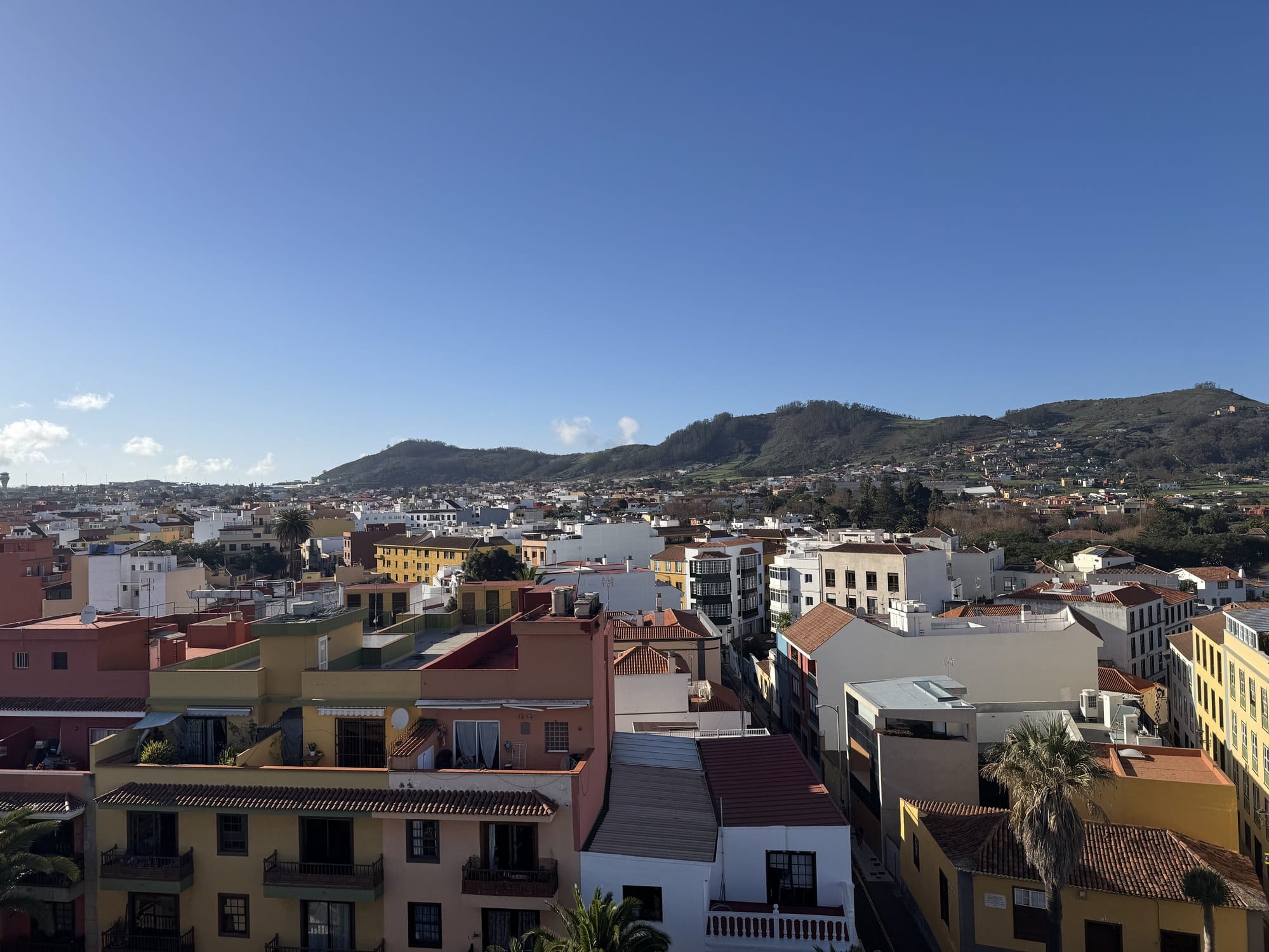 A rooftop view over the colourful old town of La Laguna, with the Anaga hills rising in the background — Tenerife