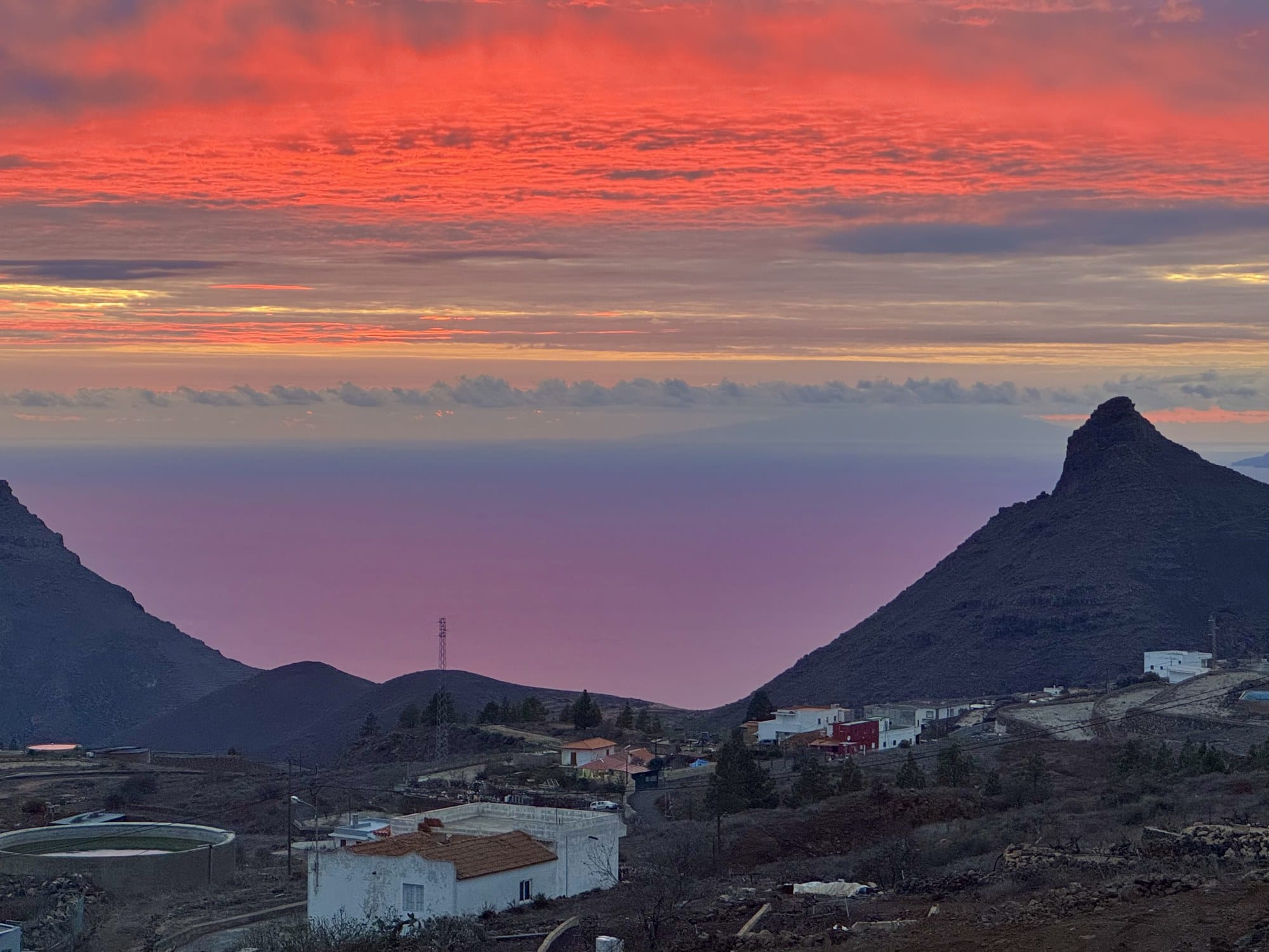 Un tramonto di fuoco rosso e viola su La Gomera visto da un mirador di montagna sopra Ifonche, con il Roque del Conde in silhouette a destra — Tenerife