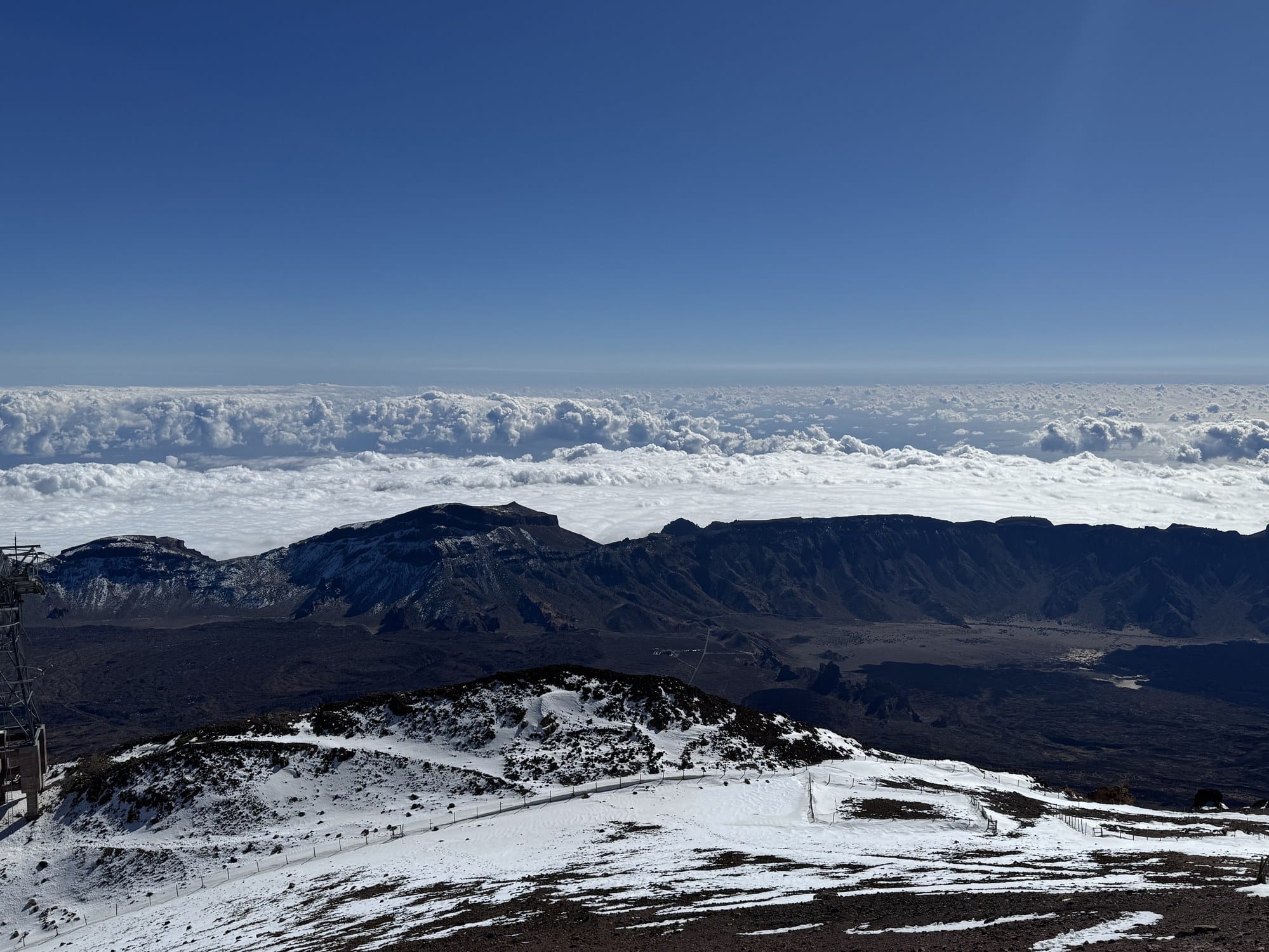 The view from the upper Teide cable car station at 3,555m, looking across the caldera floor and a sea of clouds toward the Atlantic — Teide National Park, Tenerife