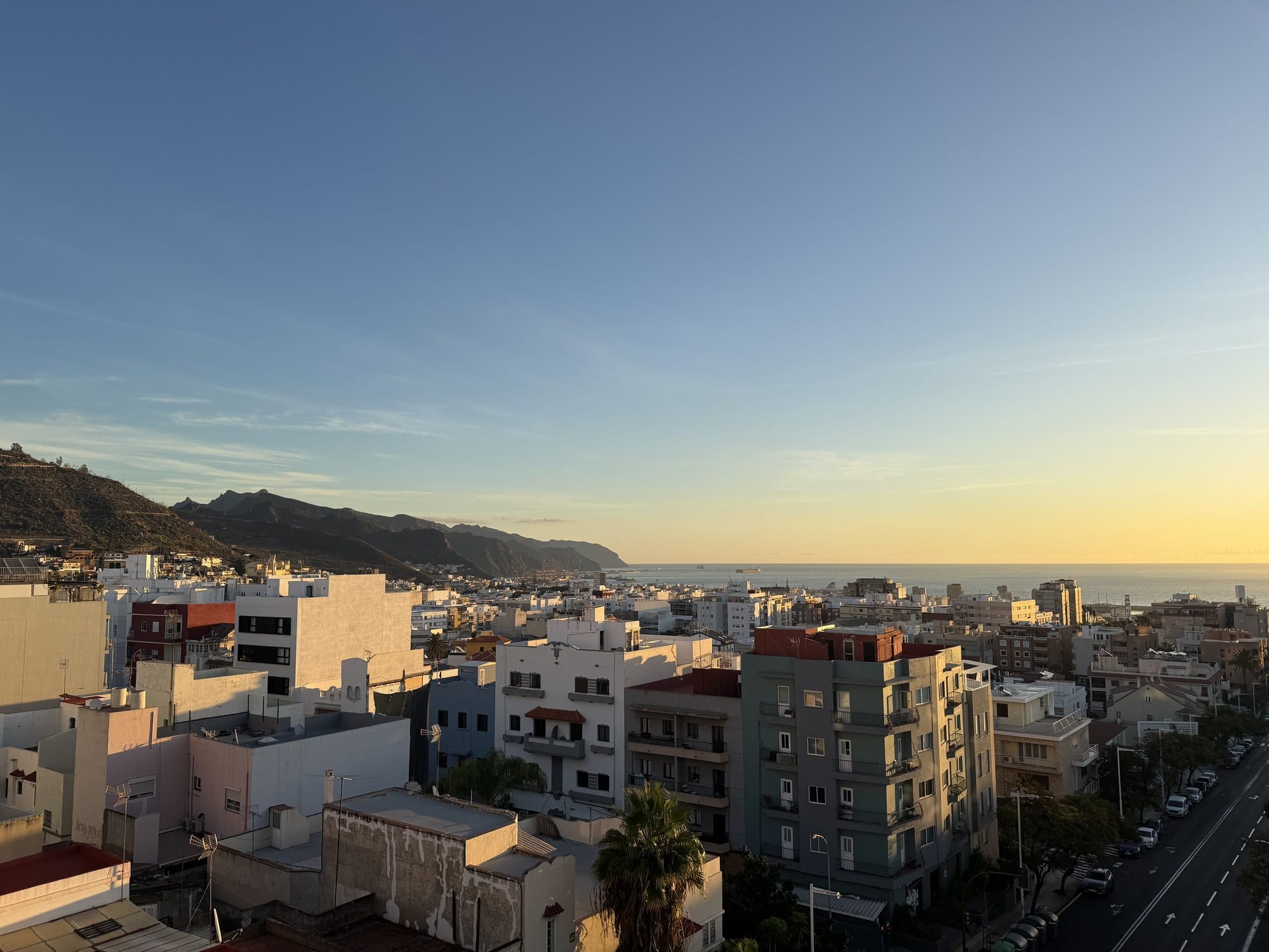 A morning view of Santa Cruz de Tenerife rooftops with the Anaga mountains in the background, bathed in golden light — Tenerife