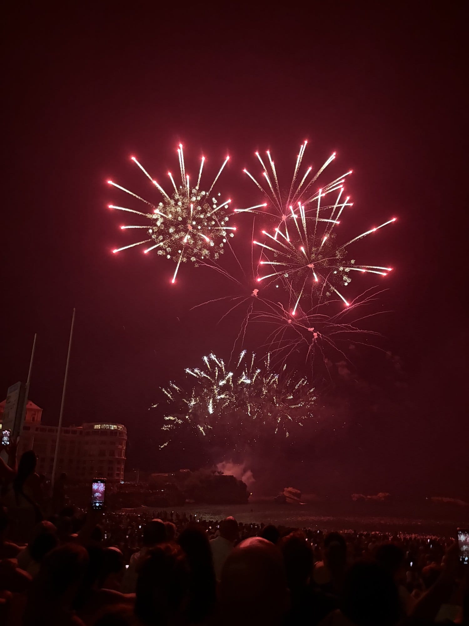 Fireworks bursting over Biarritz on the night of 15 August, with the crowd watching from the Grande Plage — French Basque Country