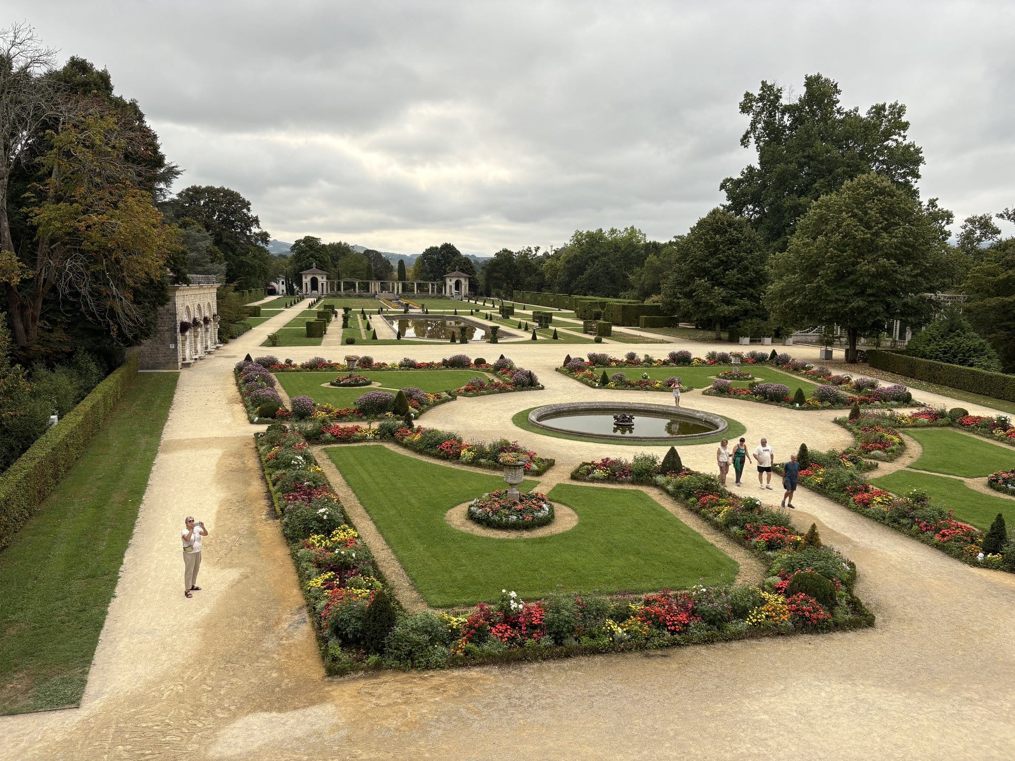 The formal French gardens of Villa Arnaga with their geometric flower beds, central fountain and columned pergola — Cambo-les-Bains, French Basque Country