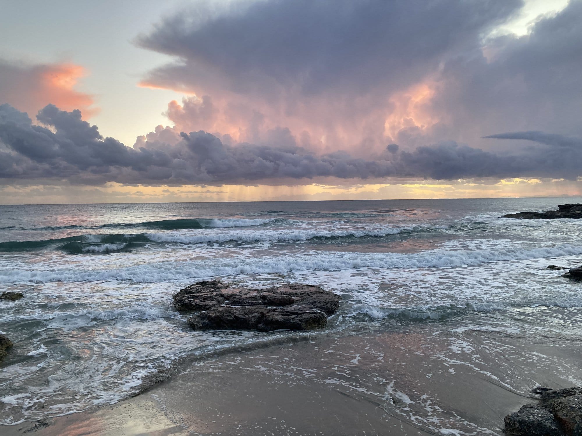 Beach sunset with warm light on sand and calm water — es Migjorn Gran, Spain