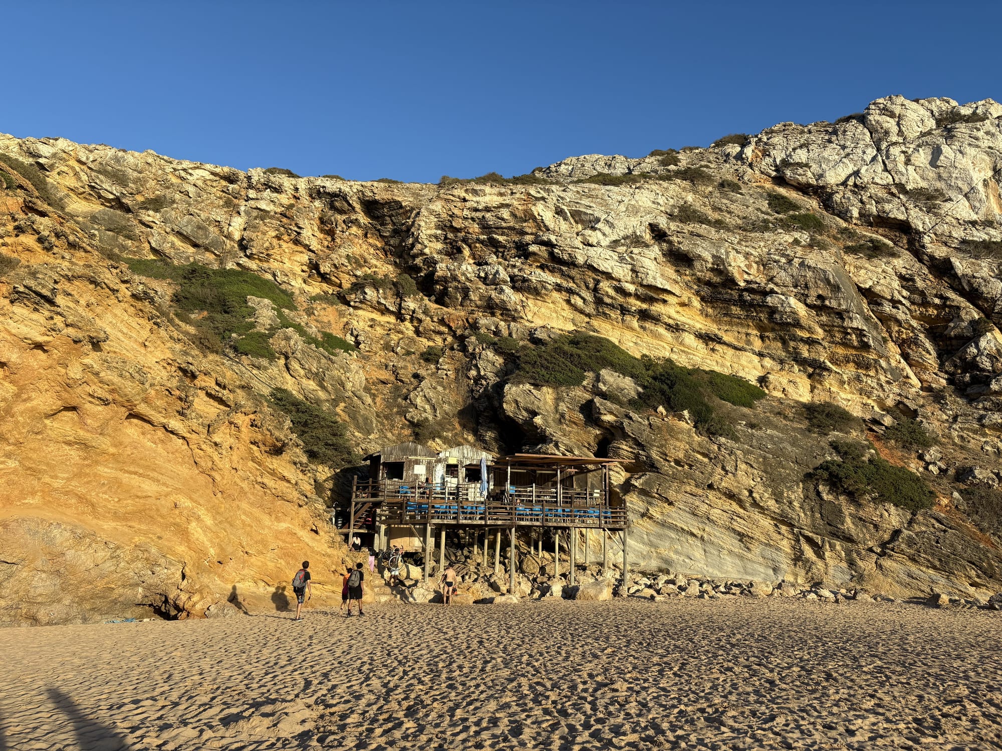 Dark sand beach surrounded by high cliffs with Atlantic waves — Praia do Tonel, Sagres