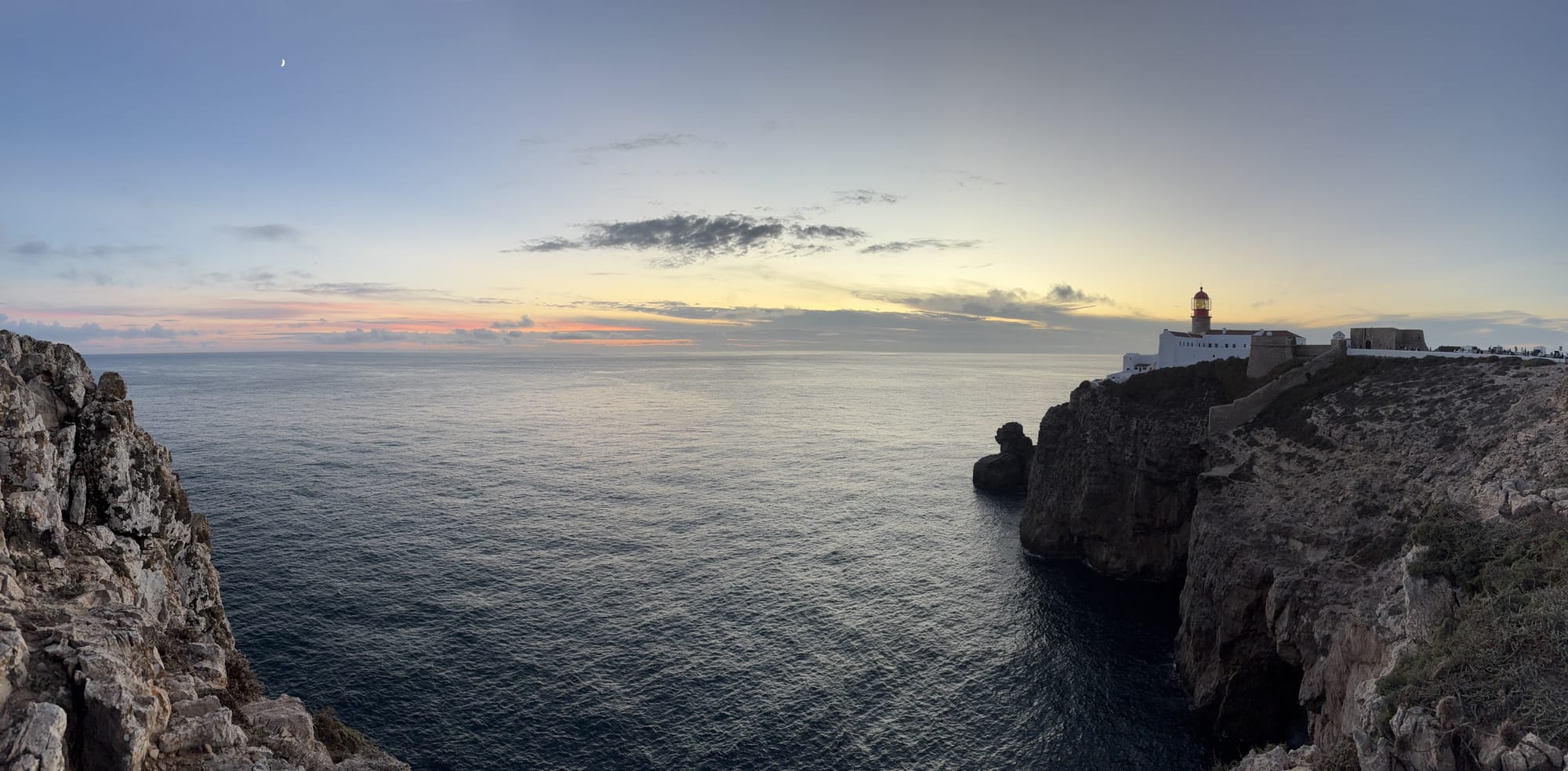 Lighthouse on rocky headland with the Atlantic stretching to the horizon at sunset — Cabo de São Vicente
