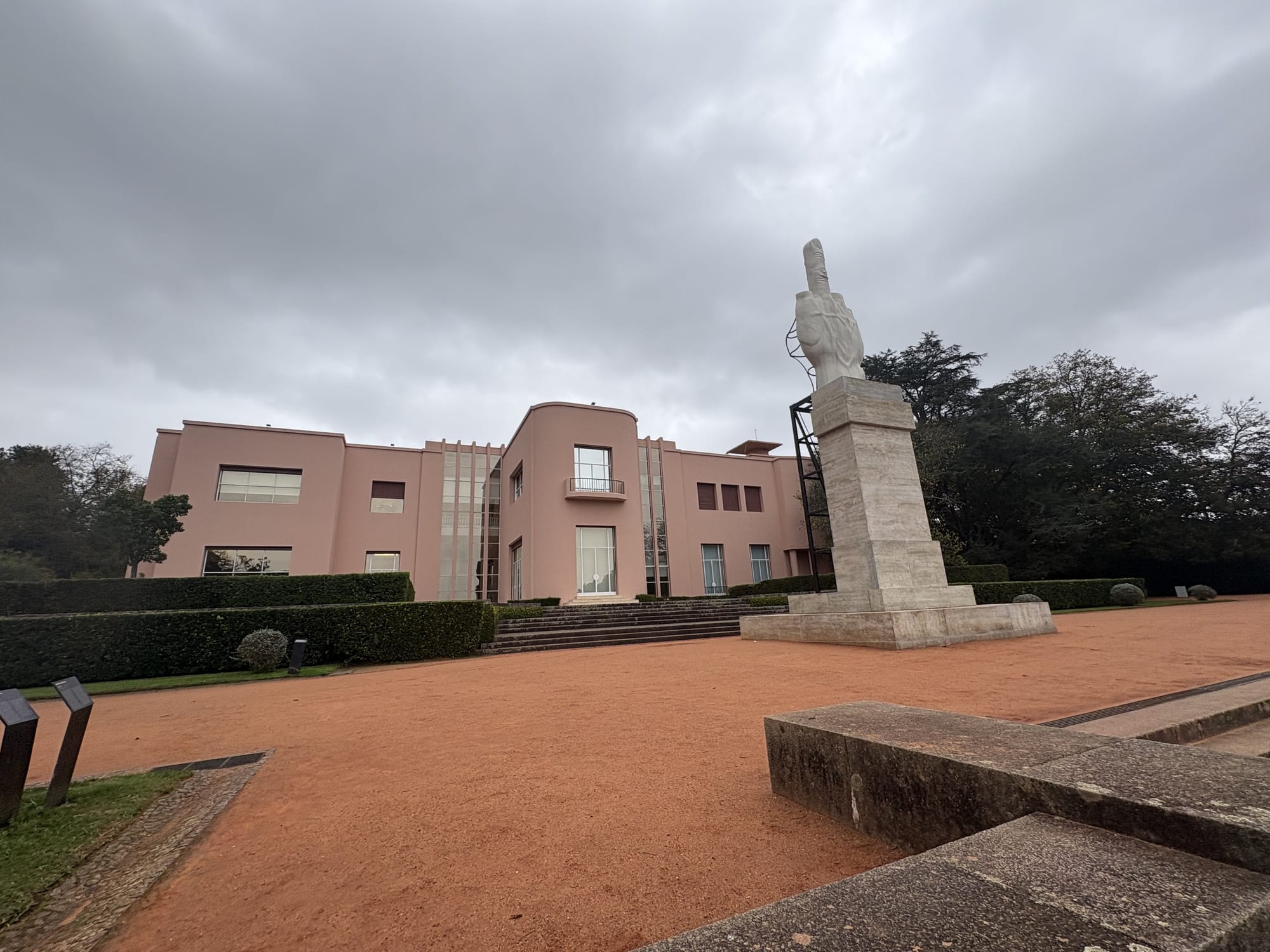 Art deco pink building with sculpture at entrance and gardens — Casa de Serralves, Porto