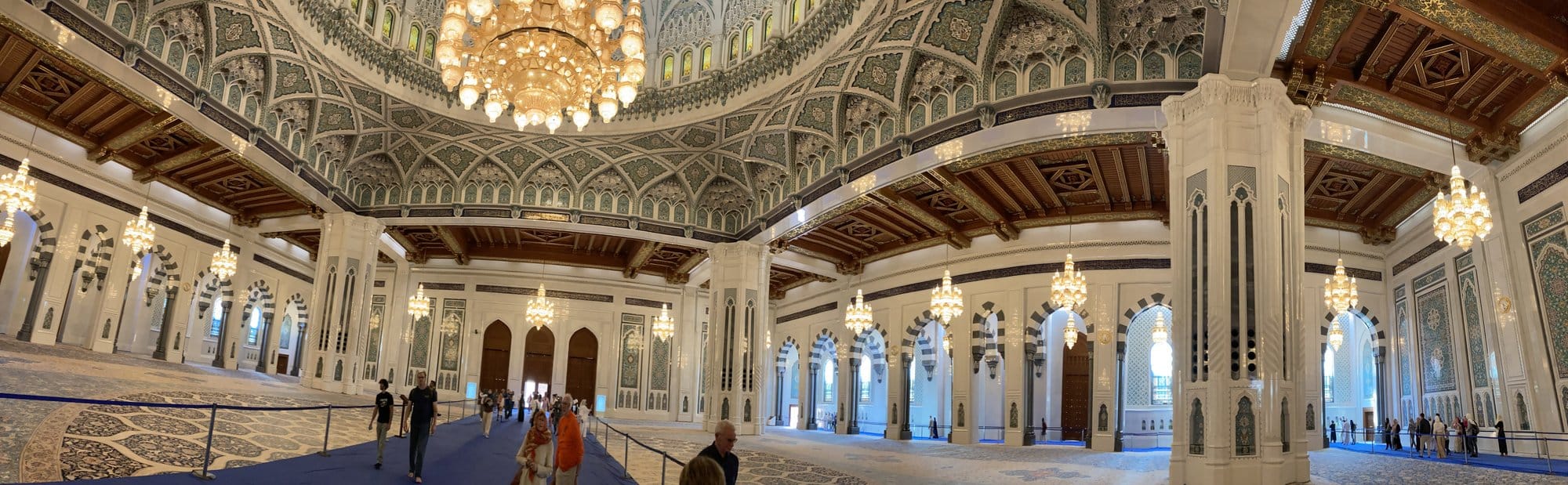 Panoramic interior of the Grand Mosque's main prayer hall with ornate dome ceiling and crystal chandeliers — Bawshar, Oman