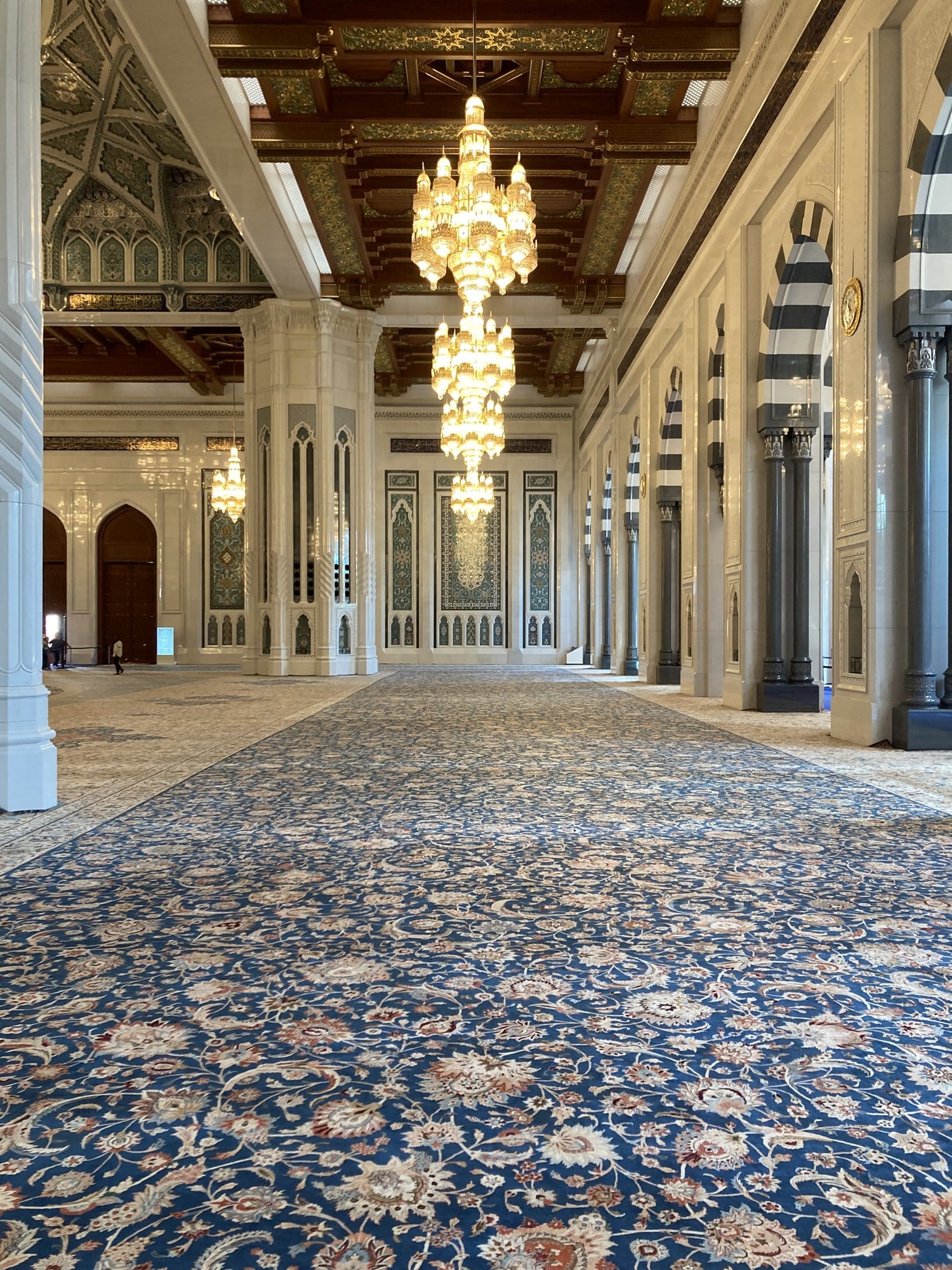 The immense Persian carpet and golden chandeliers inside the Sultan Qaboos Grand Mosque — Bawshar, Oman