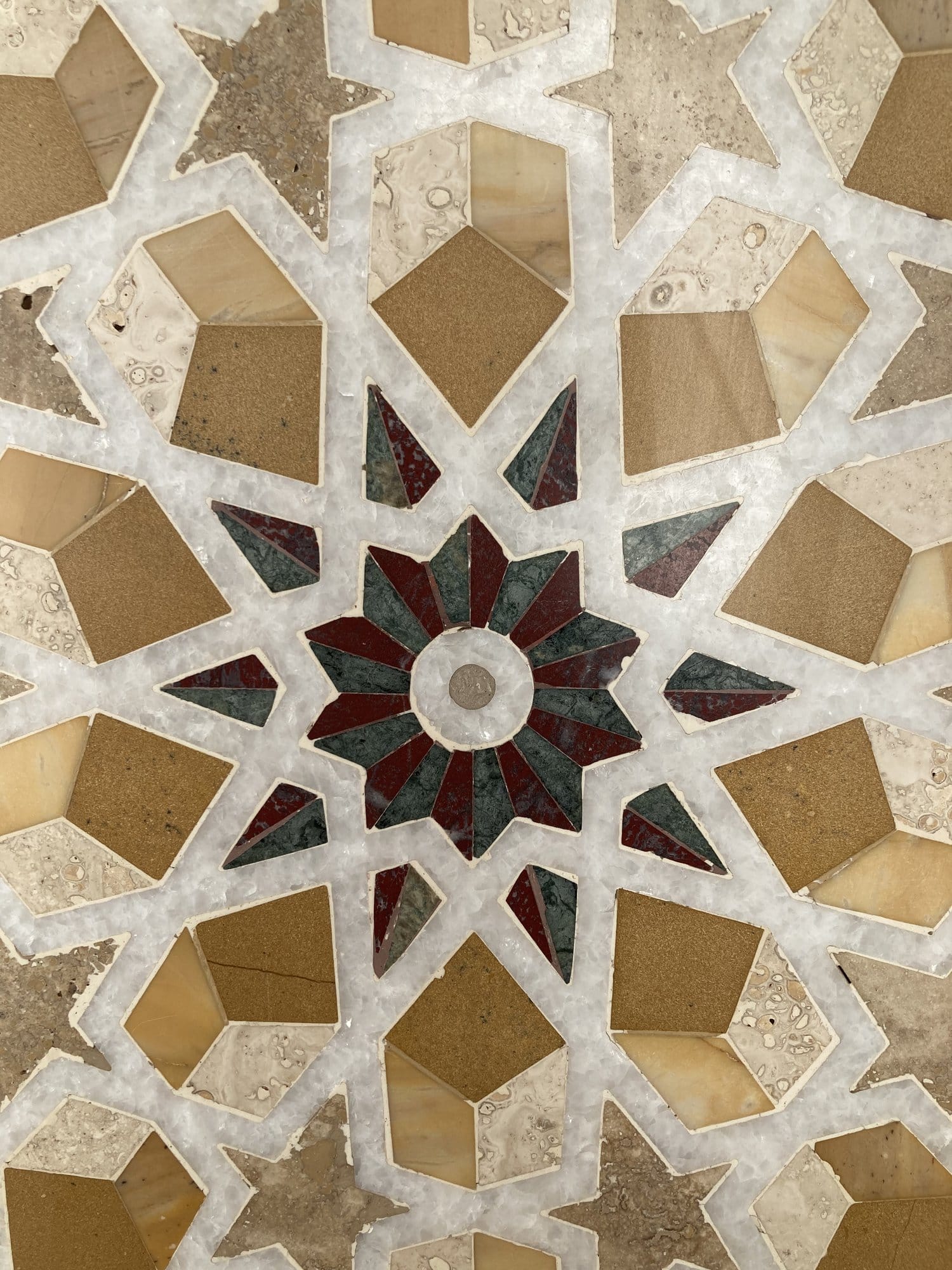 Close-up of the geometric marble inlay star pattern on the mosque floor — Sultan Qaboos Grand Mosque, Oman